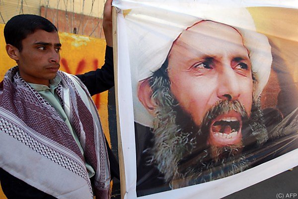 (FILES) - A file picture taken in the Yemeni capital Sanaa on October 18, 2014, shows a protester taking part in a demonstration outside the Saudi embassy against the death sentence on Saudi Shiite cleric and anti-government protest leader, Nimr al-Nimr (portrait), after he was convicted by Saudi authorities of sedition. Saudi Arabia on January 2, 2016, executed 47 people convicted of 