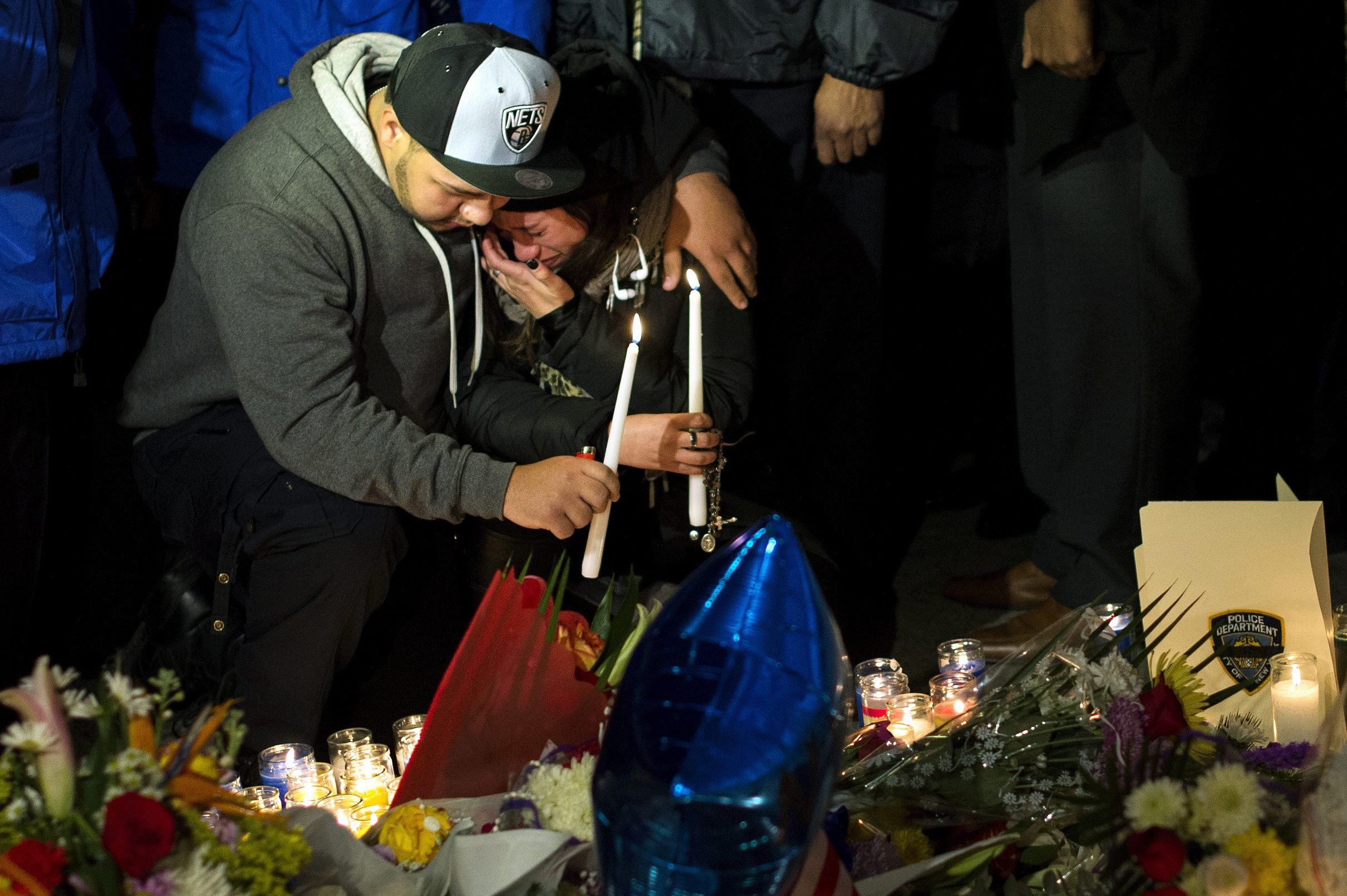 Trauernde bei einem improvisierten Denkmal für zwei ermordete Polizisten. EPA Trauernde bei einem improvisierten Denkmal für zwei ermordete Polizisten. EPA