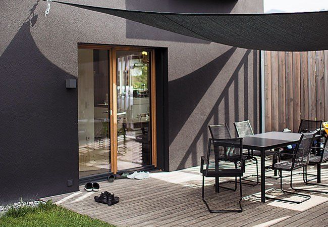 Zwischen Carport und Haus fand eine kleine Terrasse ihren Platz. Die seitliche Längslattung bieten leichten Sichtschutz und zudem einen direkten Zugang zum Garten. Foto: Darko Todorovic Zwischen Carport und Haus fand eine kleine Terrasse ihren Platz. Die seitliche Längslattung bieten leichten Sichtschutz und zudem einen direkten Zugang zum Garten. Foto: Darko Todorovic