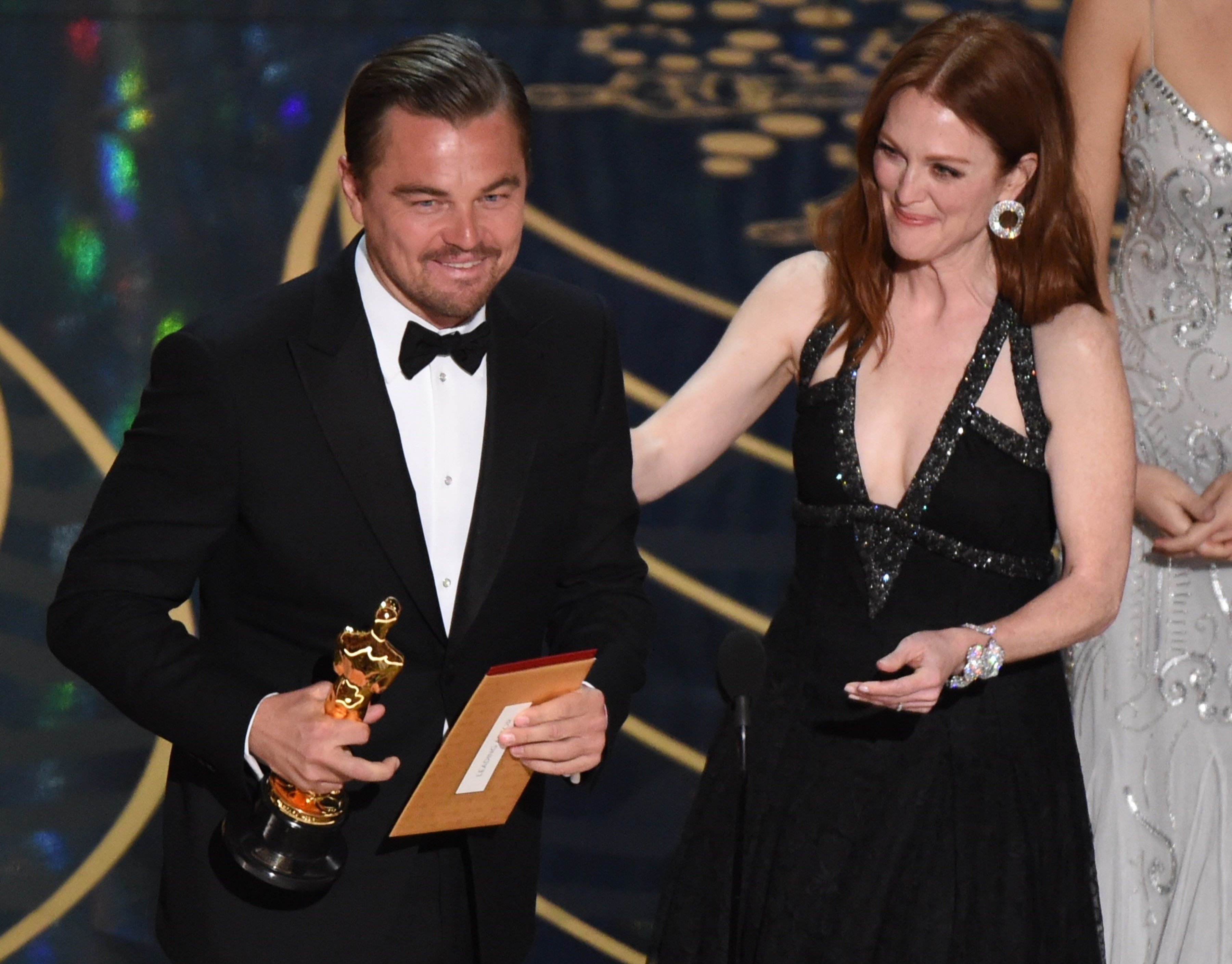 Actor Leonardo DiCaprio accepts the award for Best Actor in,The Revenant from actress Julianne Moore on stage at the 88th Oscars on February 28, 2016 in Hollywood, California. AFP PHOTO / MARK RALSTON Actor Leonardo DiCaprio accepts the award for Best Actor in,The Revenant from actress Julianne Moore on stage at the 88th Oscars on February 28, 2016 in Hollywood, California. AFP PHOTO / MARK RALSTON