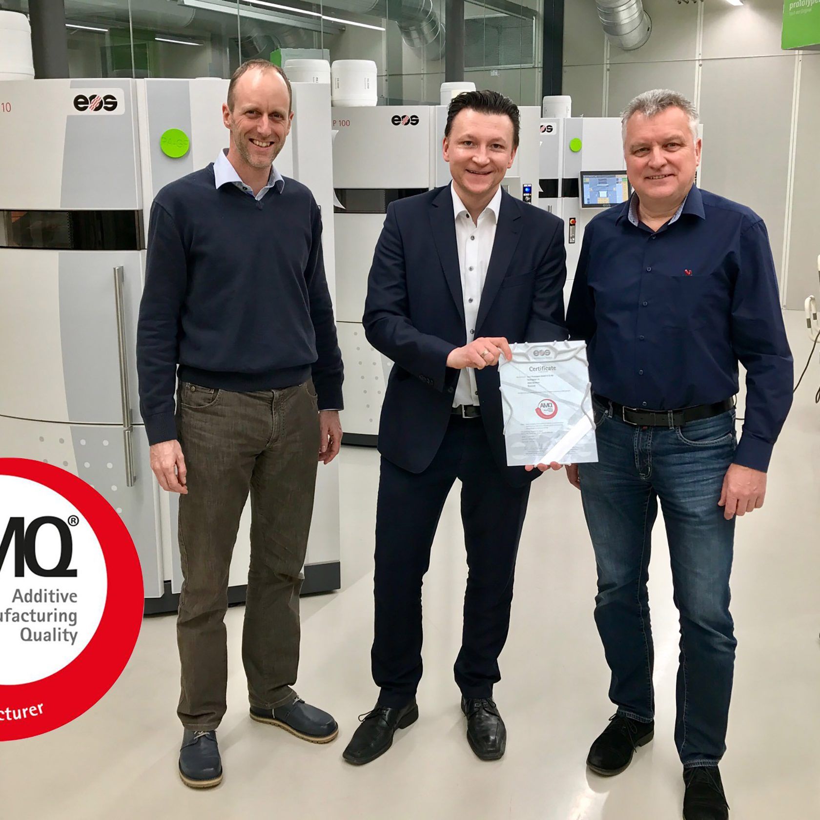 Gregor Reischle vom Weltmarktführer EOS (Mitte) überreicht Markus Schrittwieser, Rapid-Prototyping-Leiter bei 1zu1 Prototypen, (links) und Wolfgang Humml, Geschäftsführer von 1zu1 Prototypen, das AMQ-Siegel für herausragende Qualität beim Lasersintern.