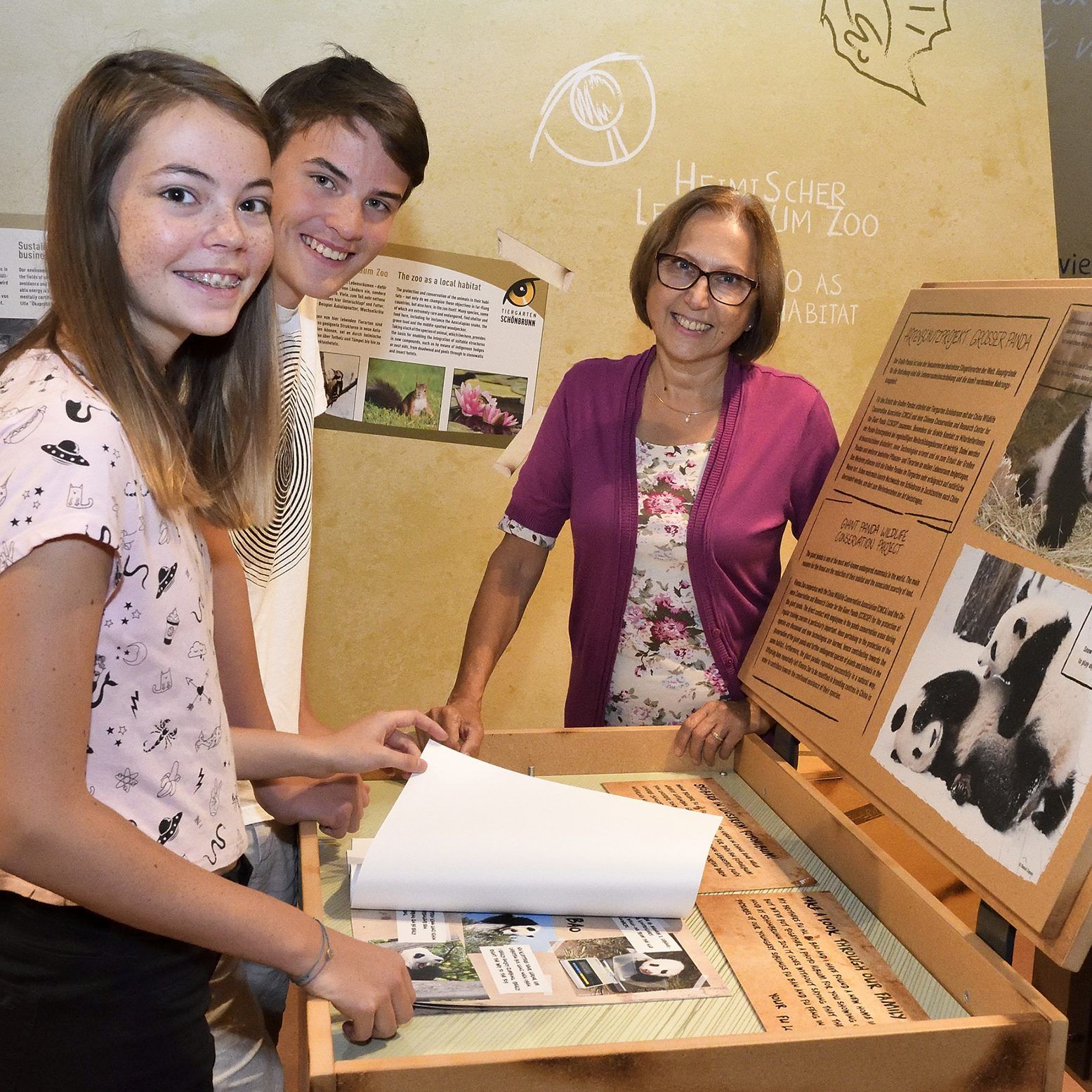 Tiergartendirektorin Dagmar Schratter zeigt Kindern die Artenschutztage-Ausstellung