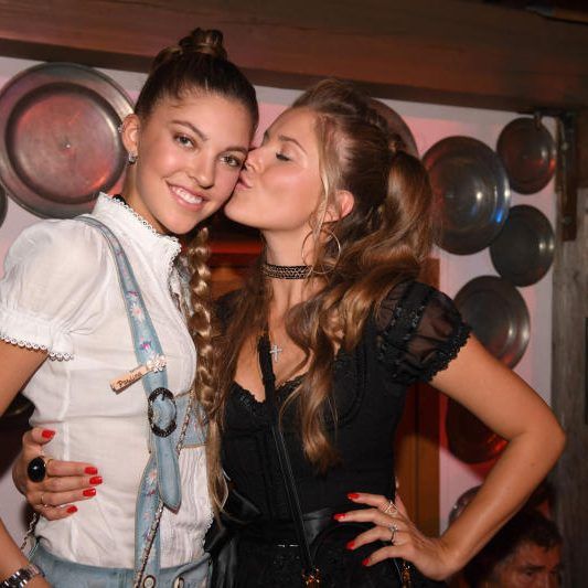 Die österreichische Sängerin Victoria Swarovski (r) küsst ihre Schwester Paulina Swarovski im Käferzelt