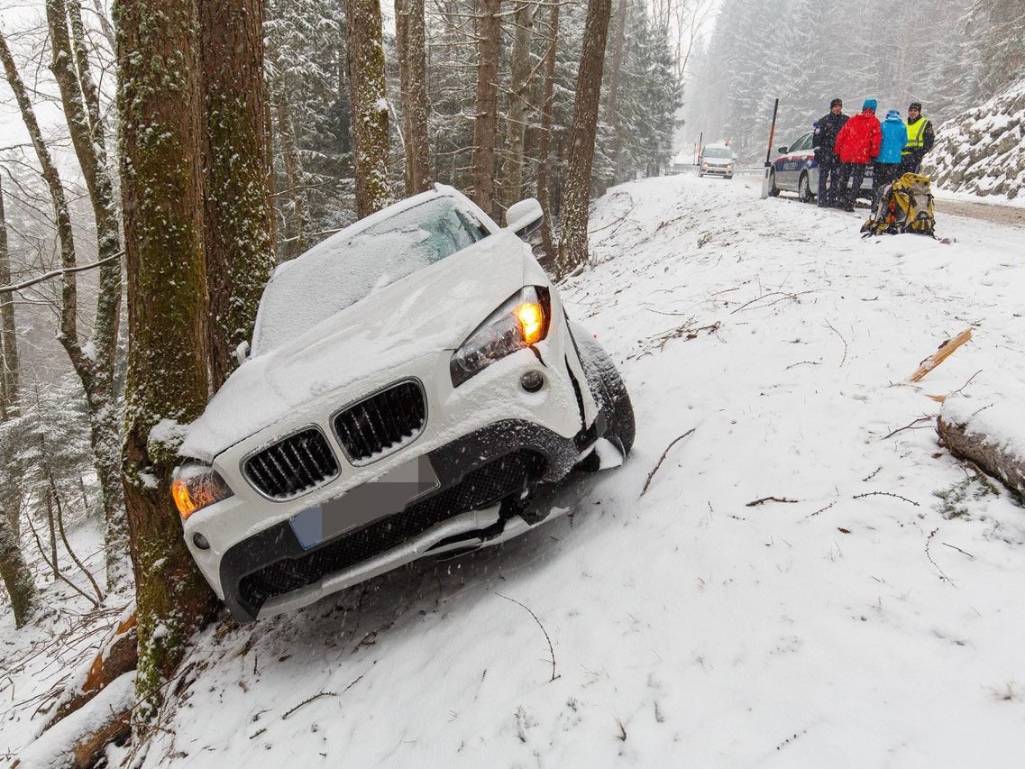 Das Auto rutschte den Hang hinunter und blieb an einem Baum hängen.
