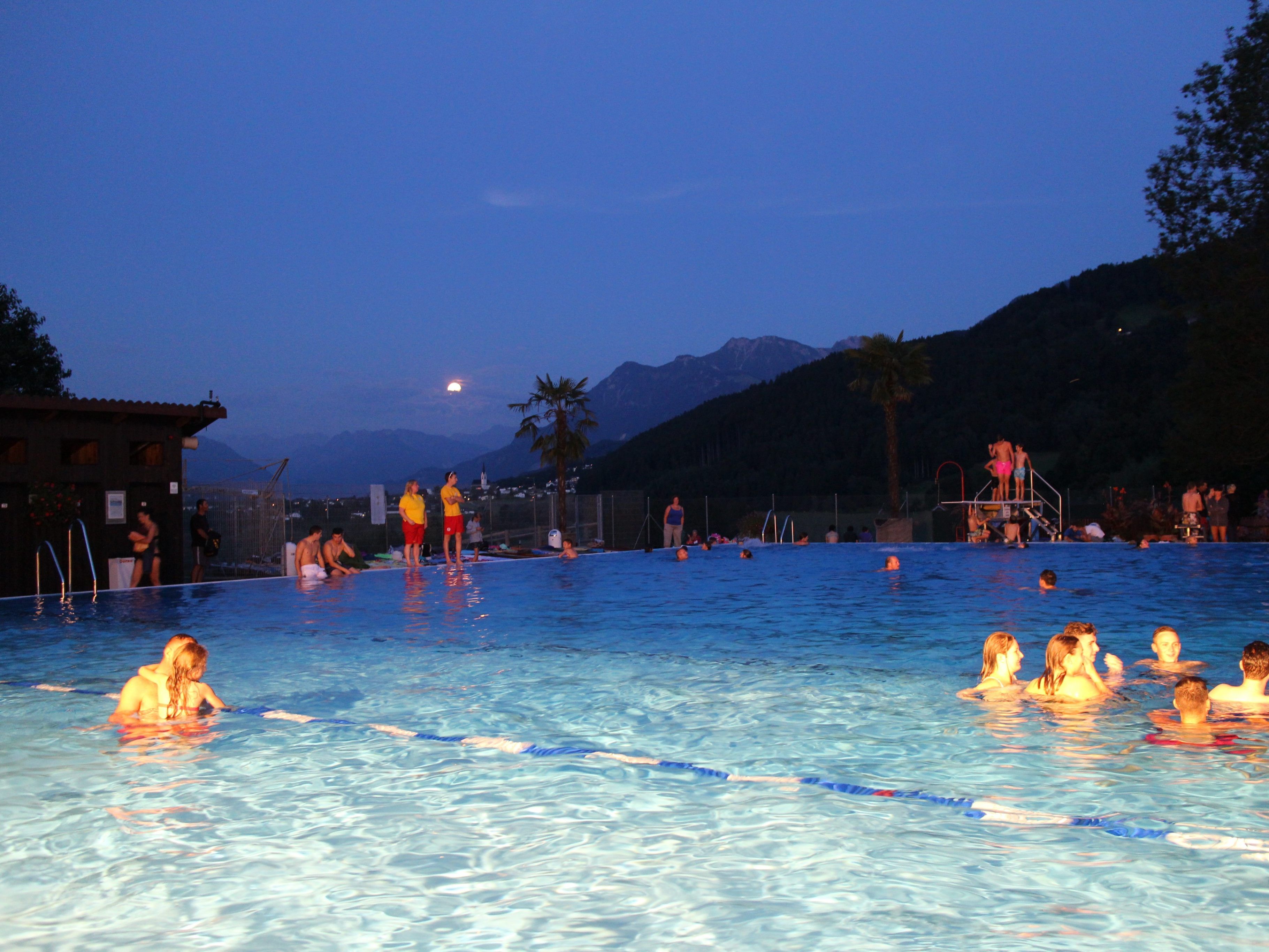 Der Panoramablick, wenn der Vollmond die Bergspitzen erleuchtet, ist ein ganz besonderes Erlebnis beim Vollmondschwimmen im 115 Jahre alten Schwimmbad.