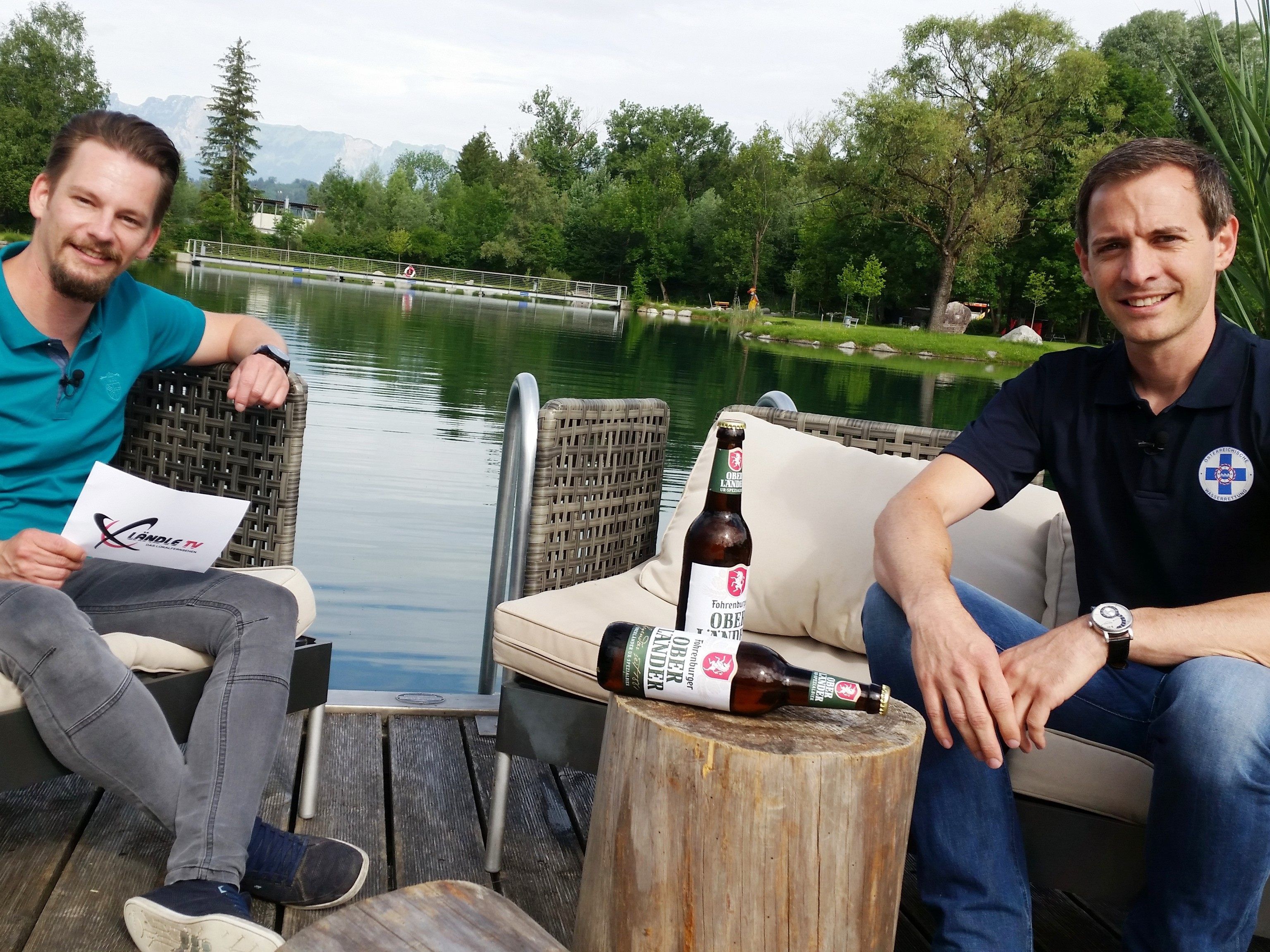 Philipp Fasser von LÄndle-TV unterhält sich mit dem Landesleiter der Wasserrettung Vorarlberg, Sebastian Helbock beim Ländle-Talk-on-tour im Naturbad Untere Au in Frastanz