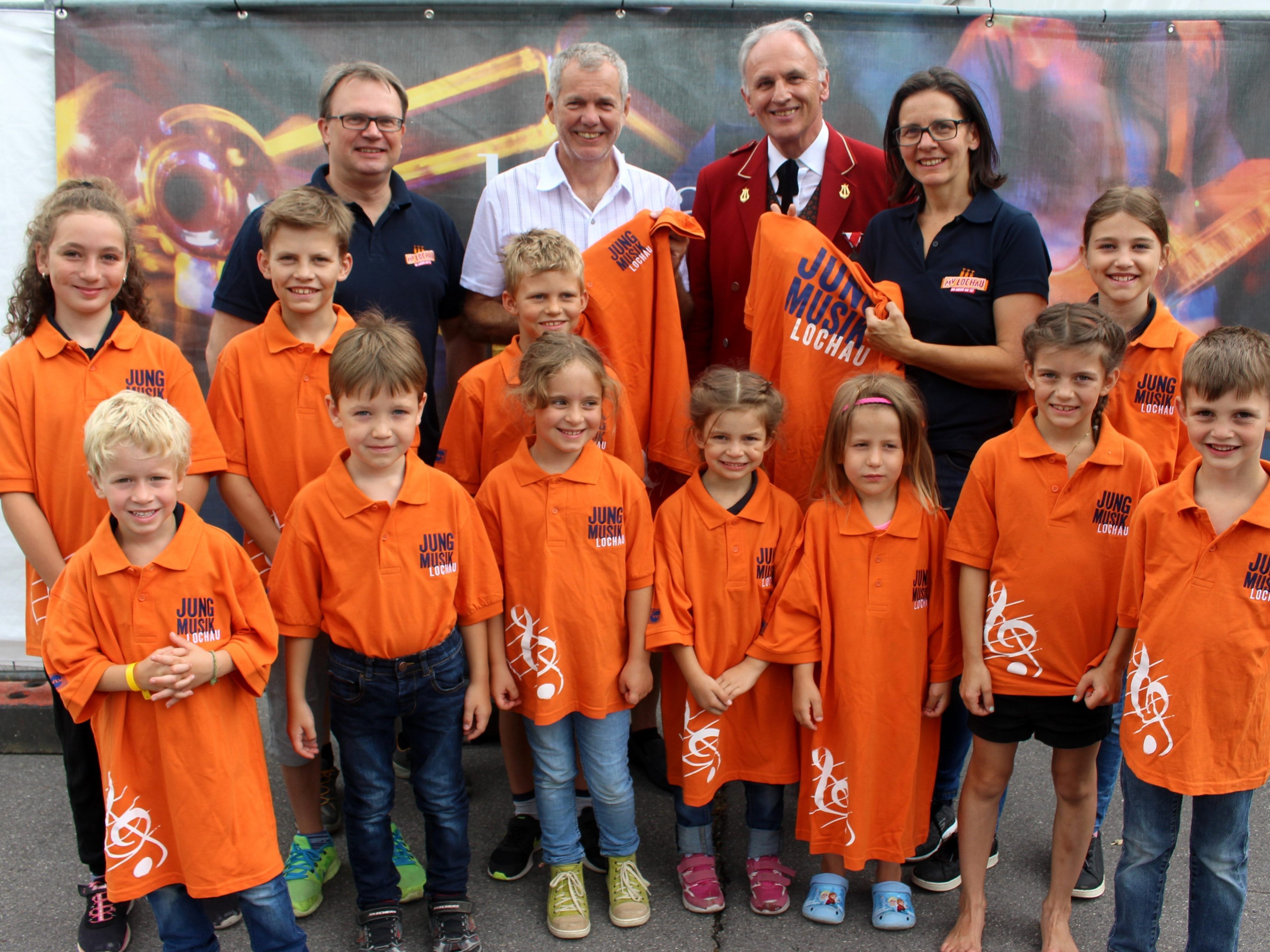 Zusammen mit dem Sponsor VLV-Direktor Robert Sturn, den Jugendbetreuern Michaela und Michael Schmid sowie Vorstand Wolfram Baldauf präsentieren sich einige Jungmusikanten im neuen Outfit.