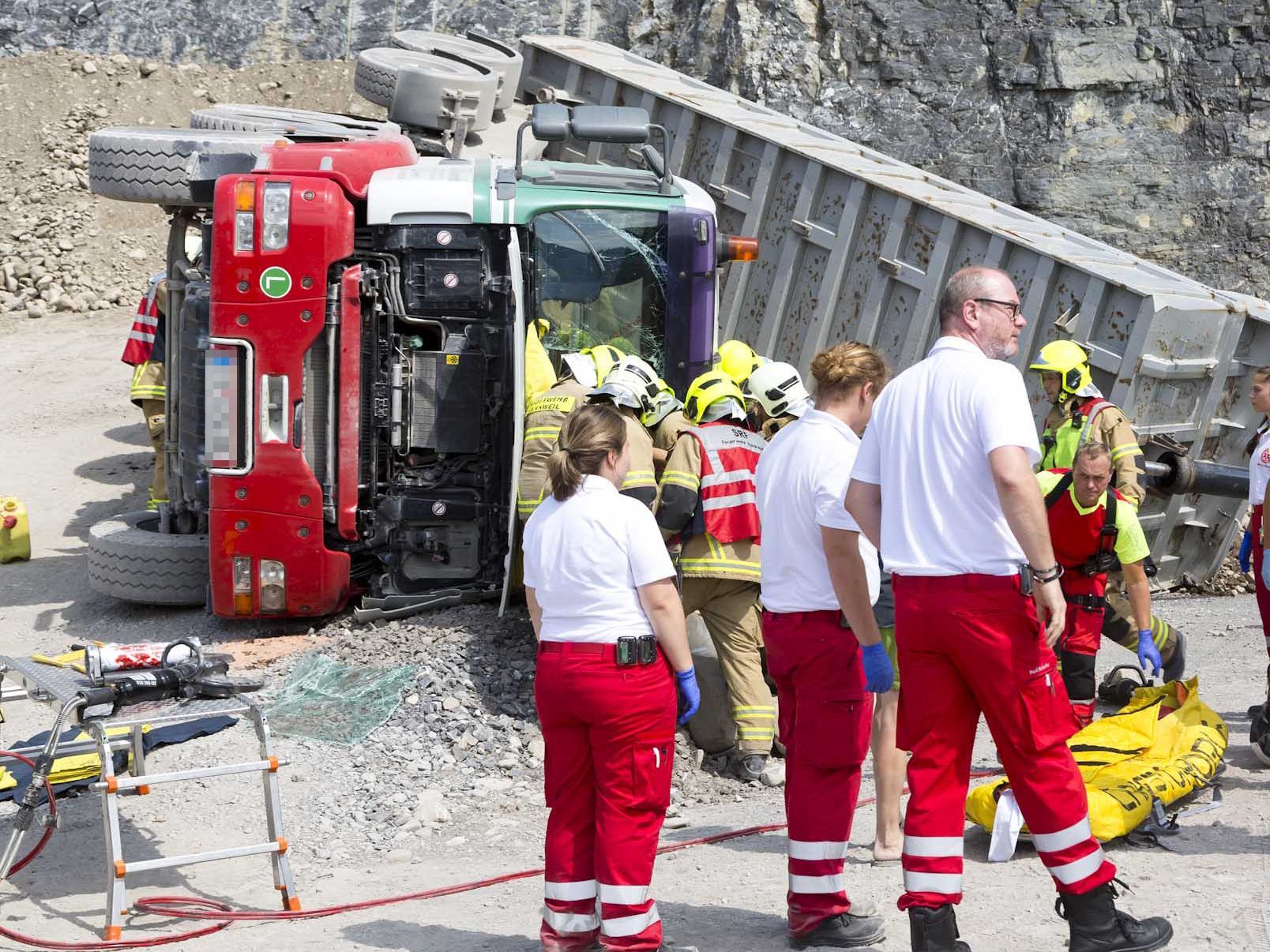 Beim Abladen seiner Fracht kippte der Lkw plötzlich um. Der Fahrer wurde eingeklemmt.