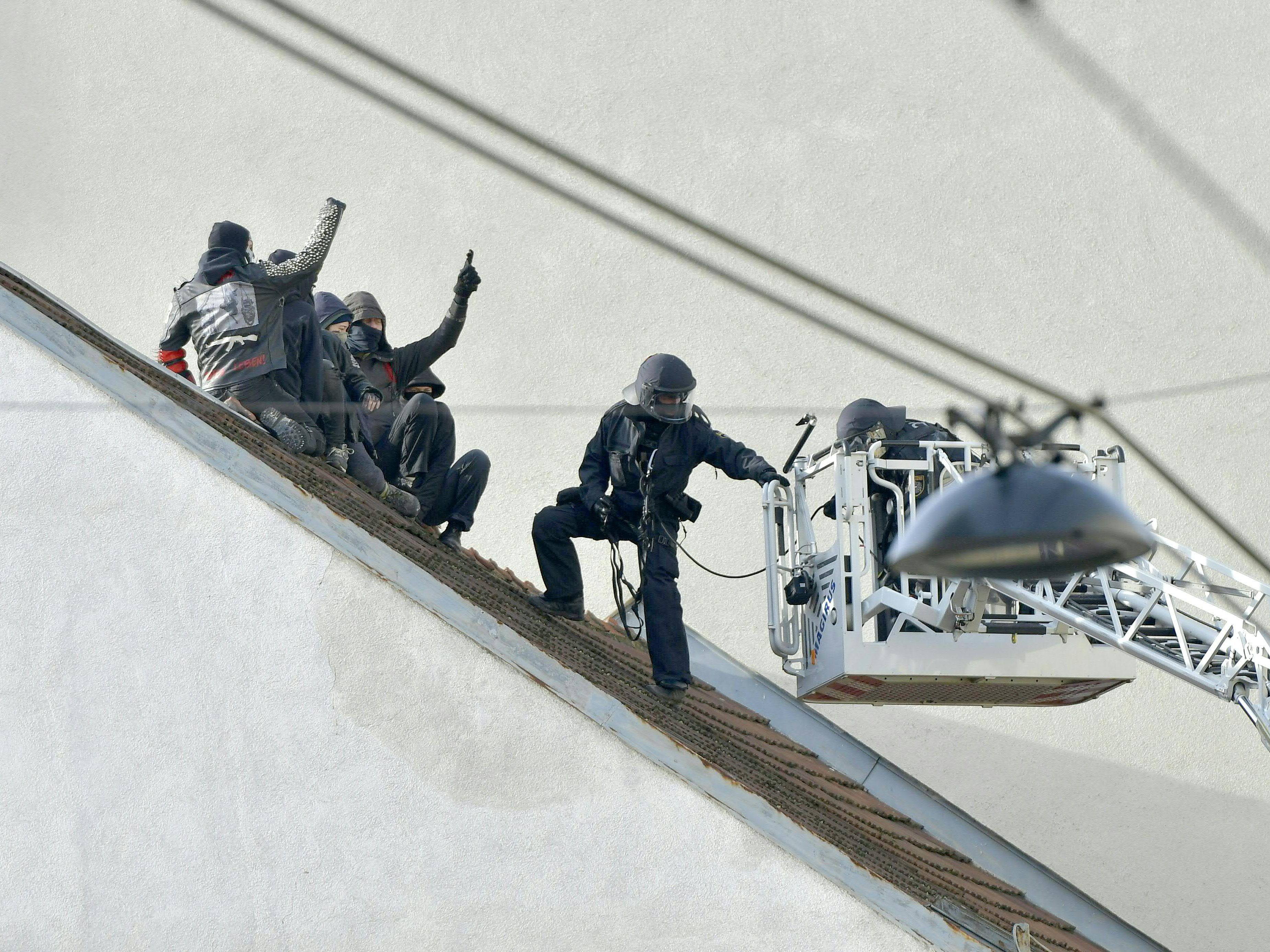 Die Aktivisten mussten mit einer Drehleiter vom Dach des Gebäudes geholt werden.