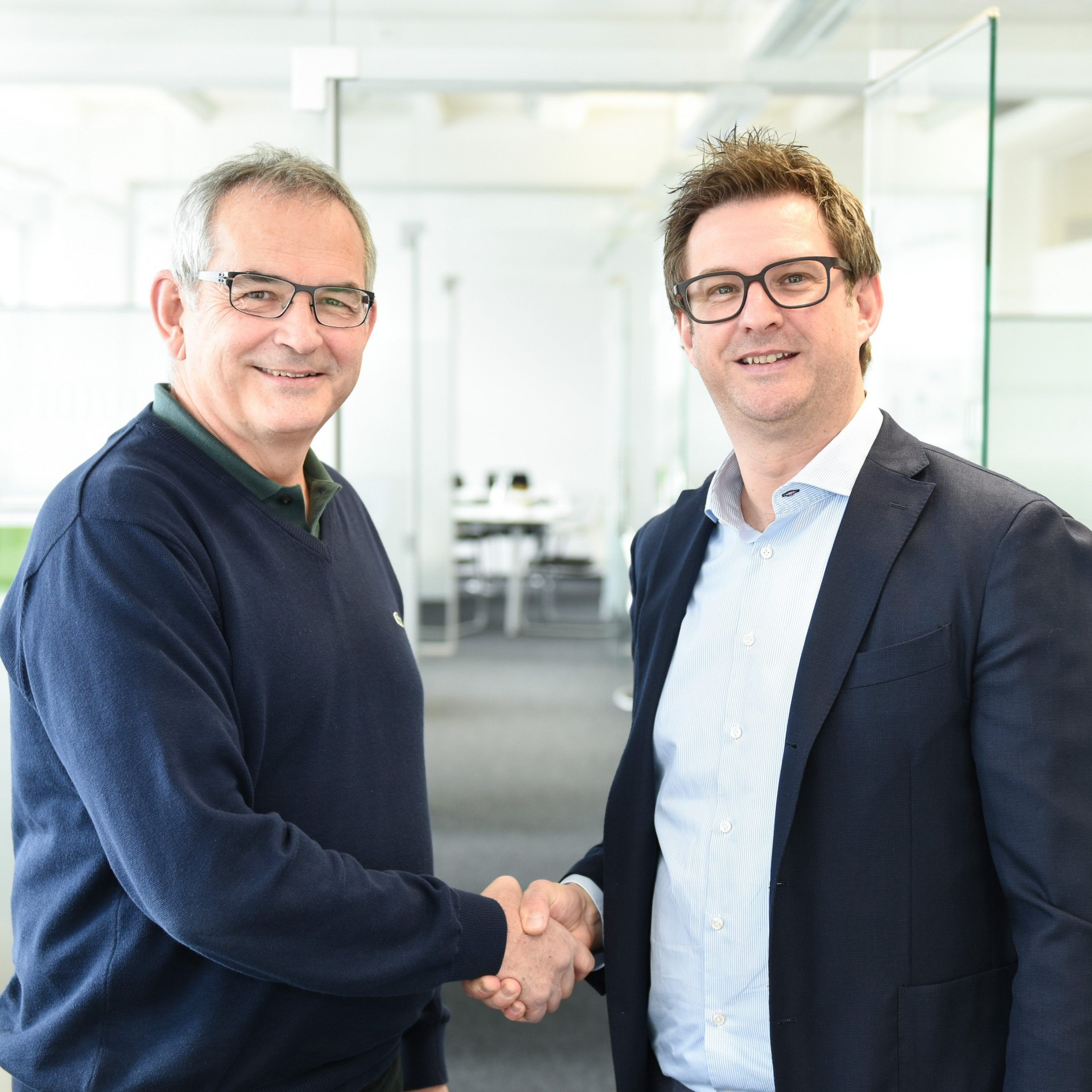 (v.l.n.r.) Peter Stämpfli, Verwaltungsratspräsident der Stämpfli AG, und Hansjörg B. Gutensohn besiegeln den Management-Buyout.