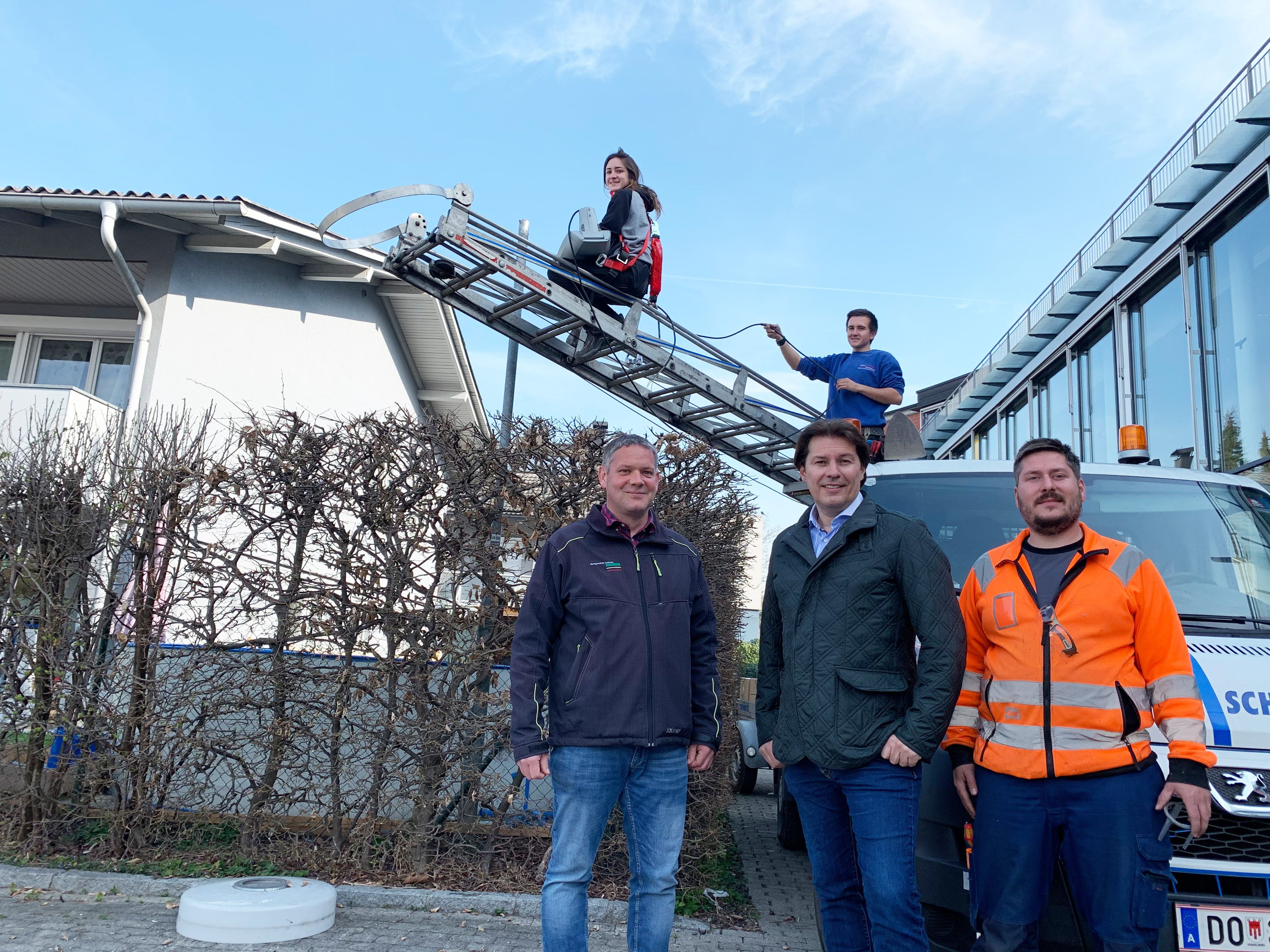 Peter Buschta von der Abteilung Tiefbau und GR Martin Fitz (v.l.n.r.) machten sich ein Bild von den der Umrüstung in der Hasenfeldstraße. Bei der Arbeit: Marcel Stenzel vom Bauhof (u.r.) und Jana Weidacher sowie Andreas Schönbeck von der Firma Schönbeck auf der Leiter.