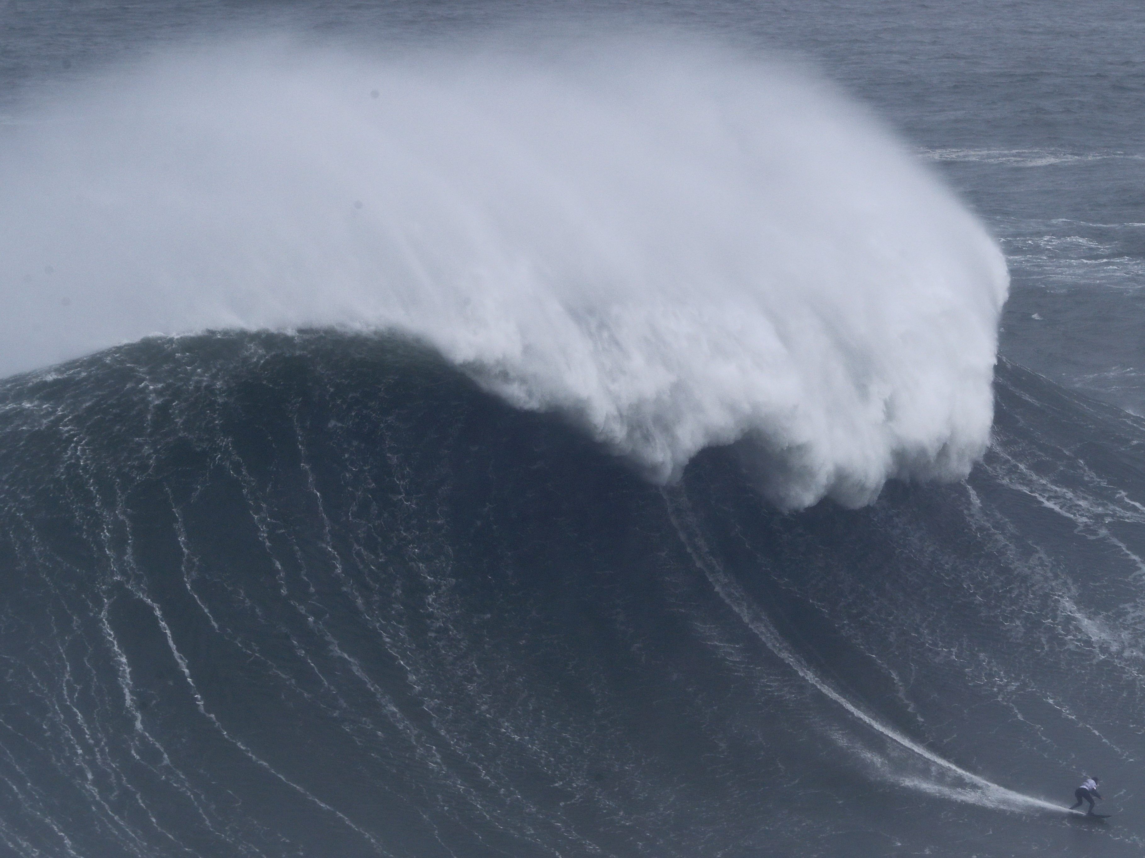 Der Surfer wurde von einer großen Welle erfasst.