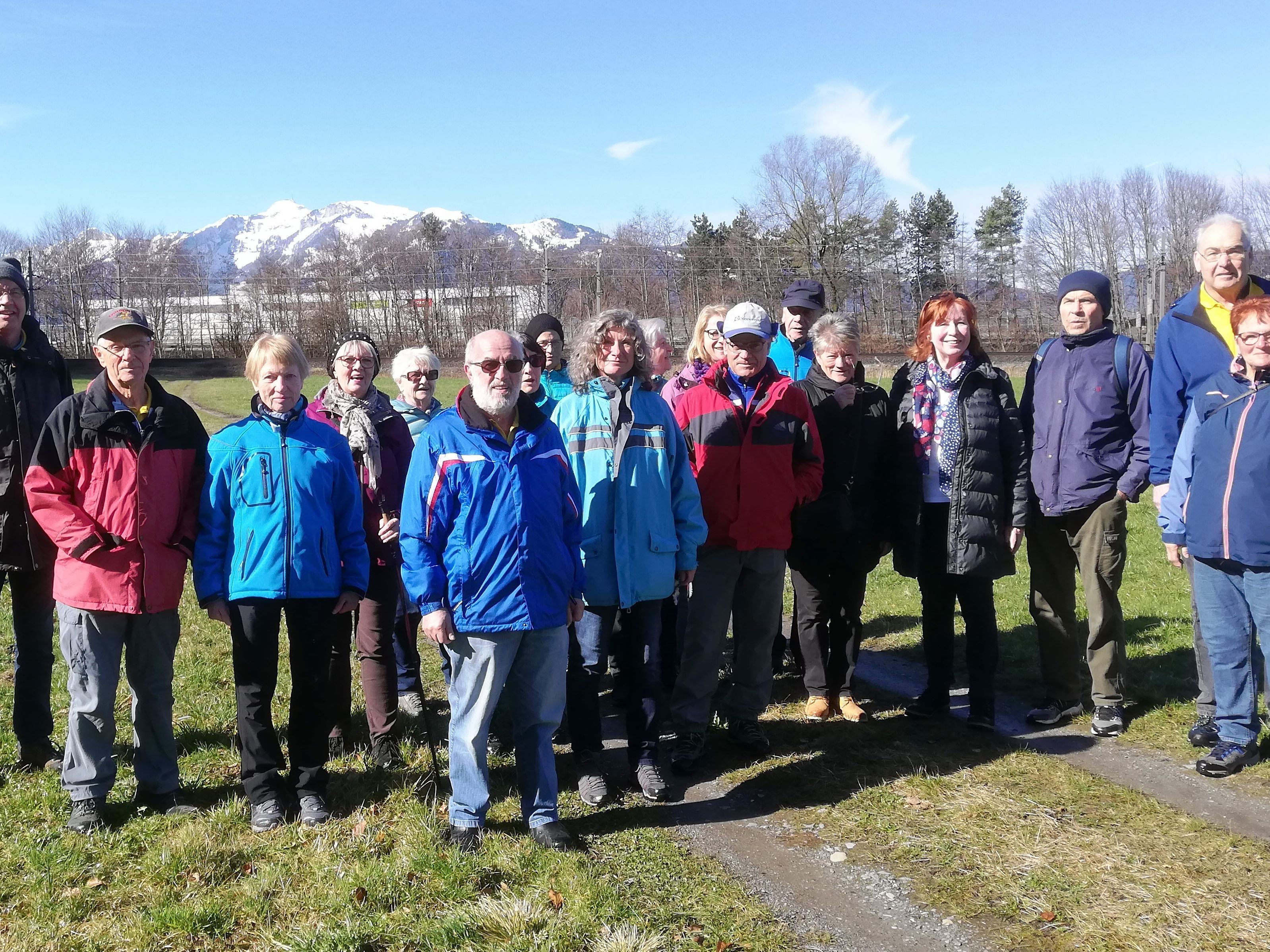 Die Wanderer auf der Wiese vor dem Sattelberg; Im Hintergrund die Schweizer Berge