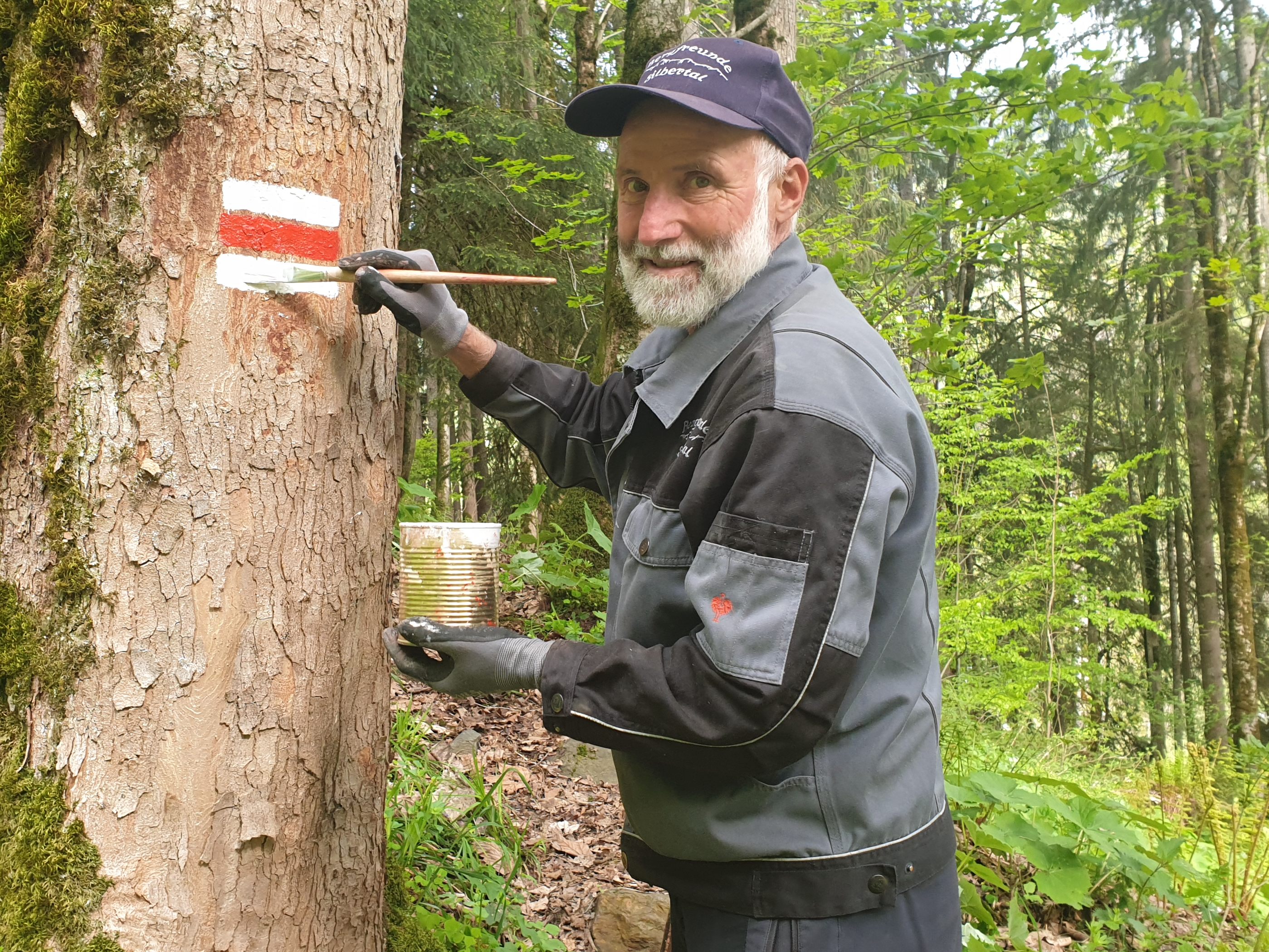 Walter Zudrell markiert einen Baum weiß-rot-weiß.