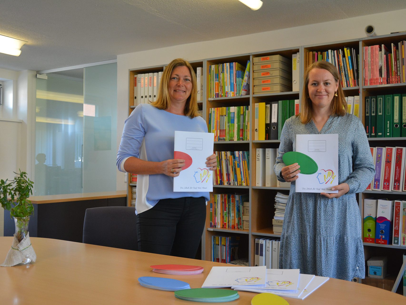 Schulsekretärin Gabriele Kergel (links) und Christine Bösch-Vetter (rechts), Elternvereinsobfrau, haben sich gemeinsam für die Schulhefte ganz ohne Plastikeinbände eingesetzt. Stolz präsentieren sie das Ergebnis. Ab Herbst kommen sie in der Mittelschule zum Einsatz.