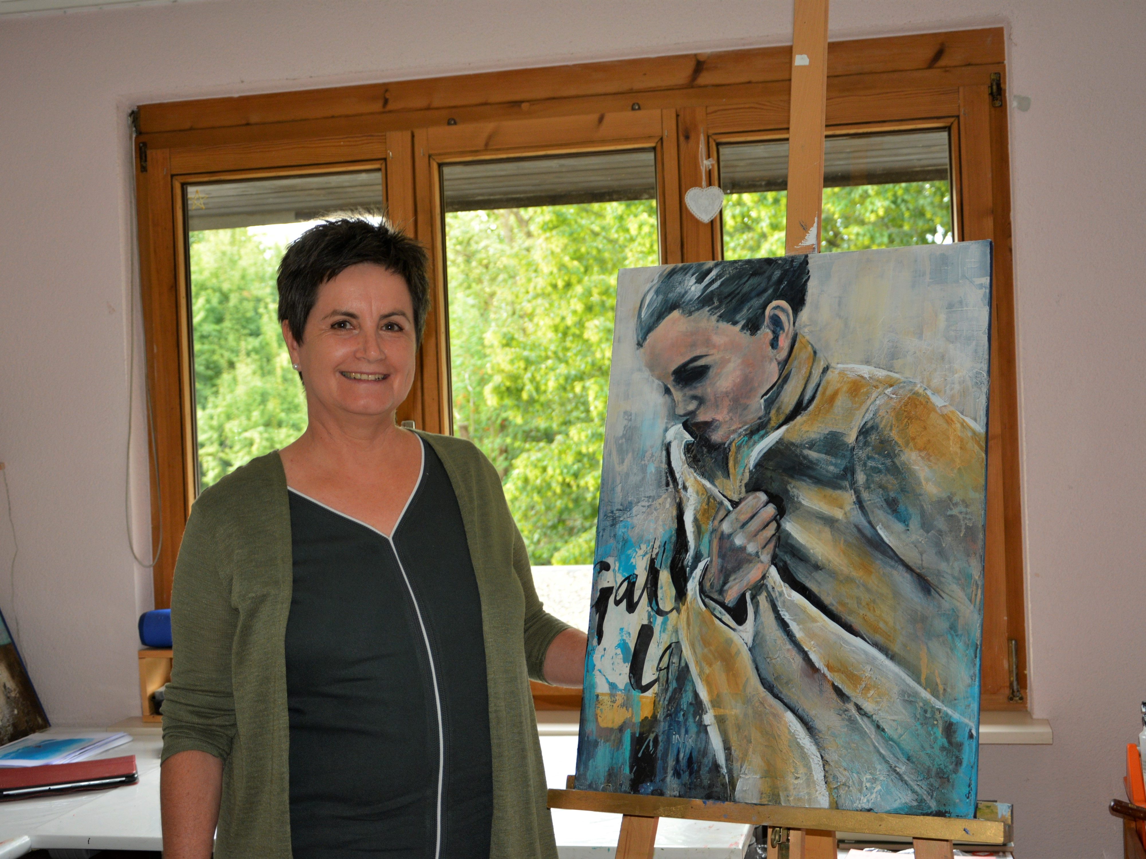 Irene Koschina zeigt ein Frauenbild in ihrem Atelier.