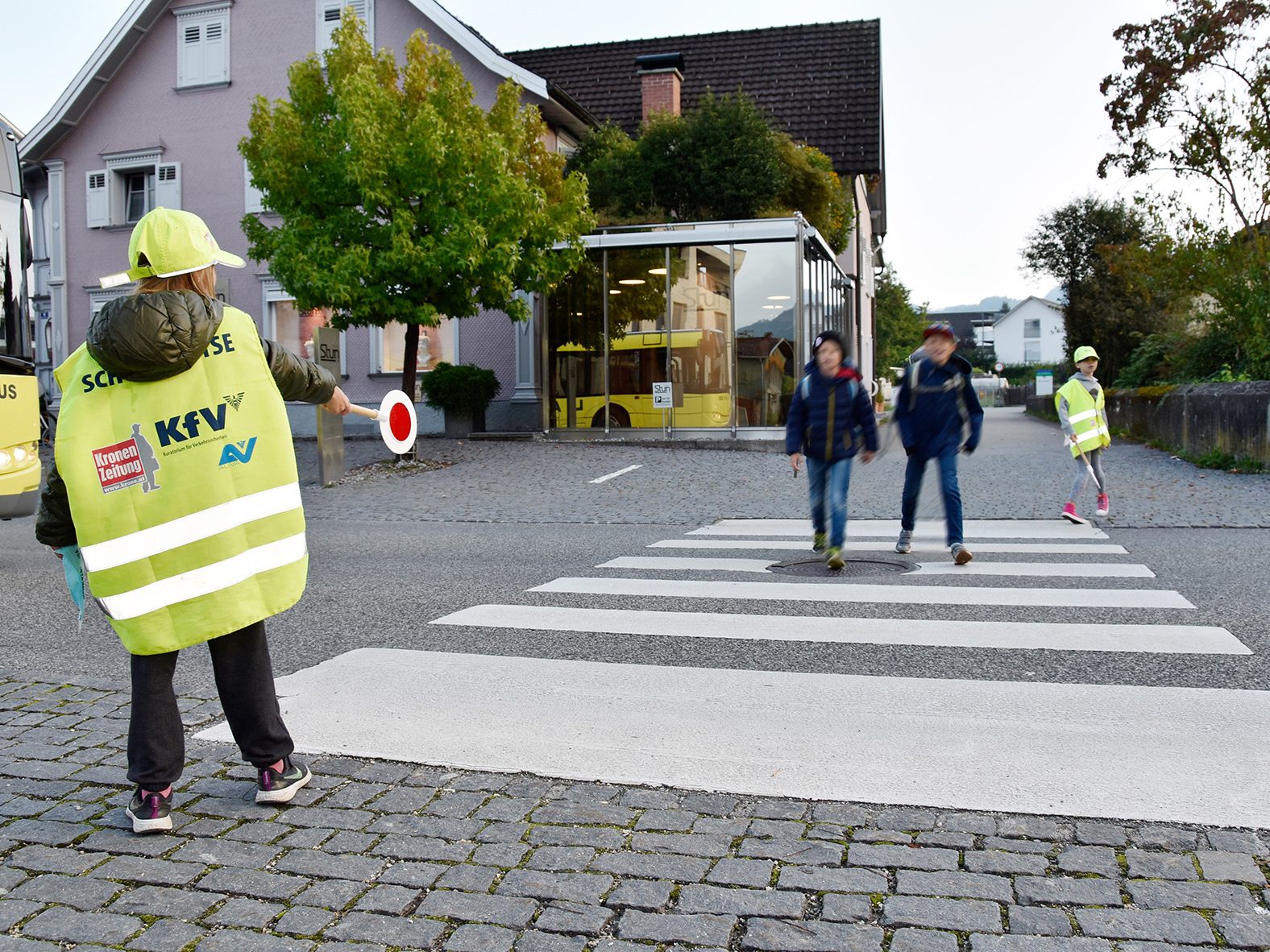 Rankweiler Polizist*innen zeigen den Kindern, wie ein Schutzweg zu sichern ist.