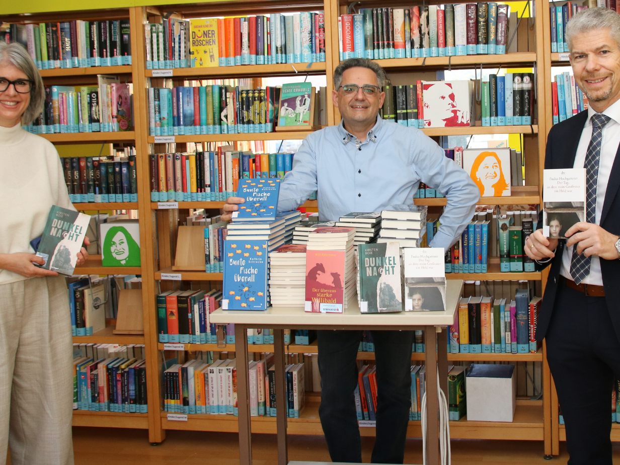 Vlnr: Angelika Kaufmann (mit Jürgen Schacherl für die Bibliothek des Gymnasiums verantwortlich) mit Gerald Fenkart und Thomas Schreiber anlässlich der Übergabe der Bücher in der Bibliothek des Gymna-siums in Bludenz.