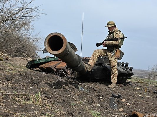 Ukrainischer Soldat betrachtet russisches Panzerwrack Ukrainischer Soldat betrachtet russisches Panzerwrack