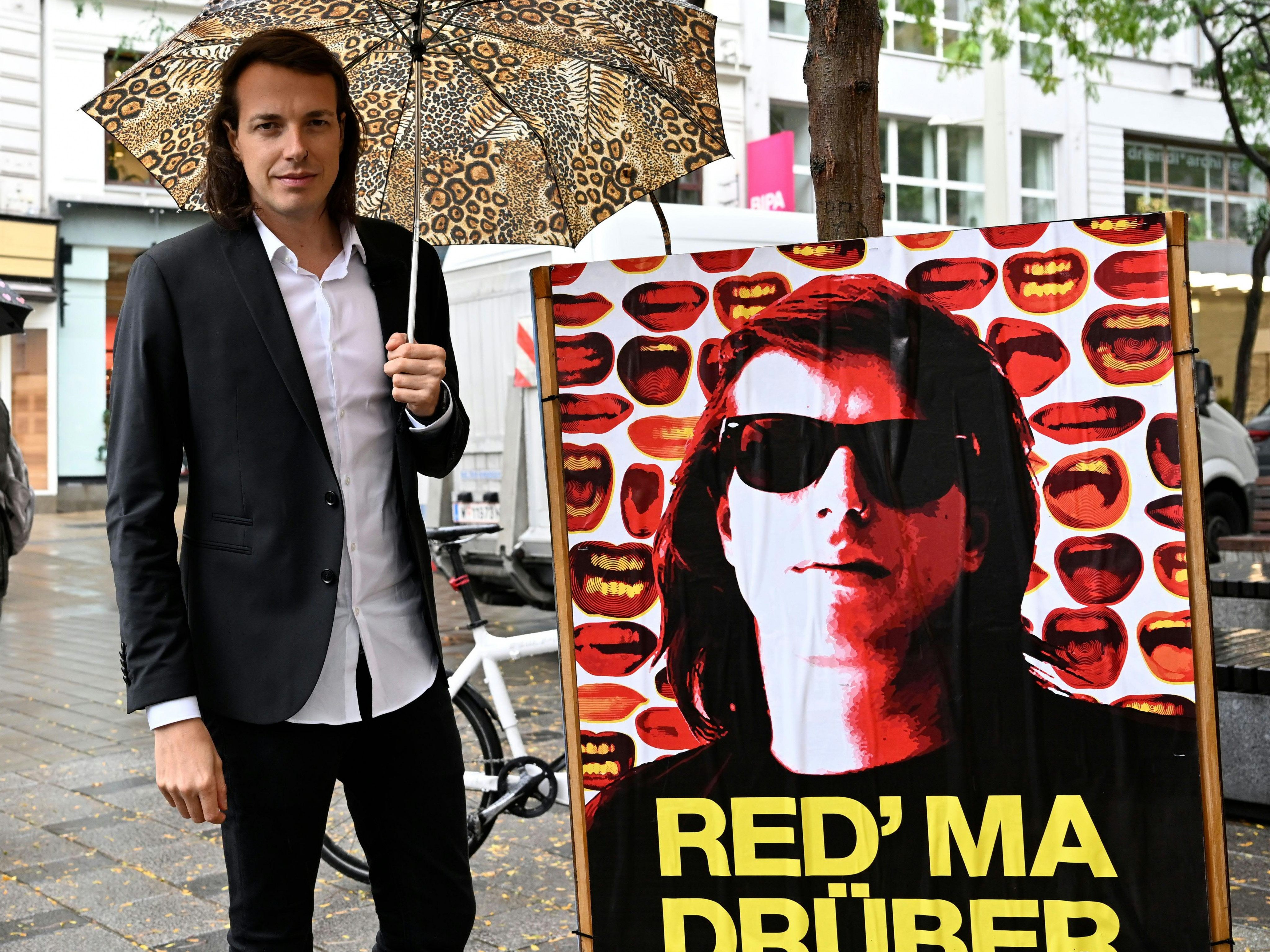 BP-Wahl: Kandidat Dominik Wlazny neben einem Plakat mit seinem Gesicht. BP-Wahl: Kandidat Dominik Wlazny neben einem Plakat mit seinem Gesicht.
