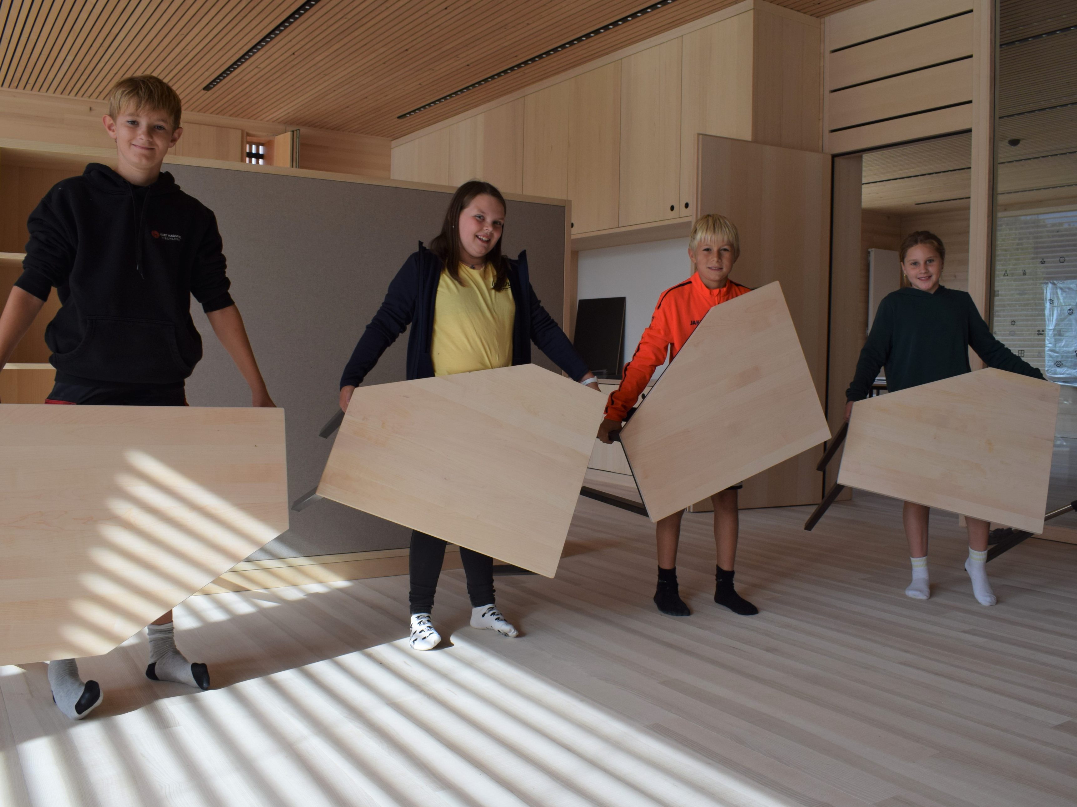 Hittisauer Mittelschüler tragen stolz die neuen Fünfeck-Tische in ihre Klassen. Hittisauer Mittelschüler tragen stolz die neuen Fünfeck-Tische in ihre Klassen.