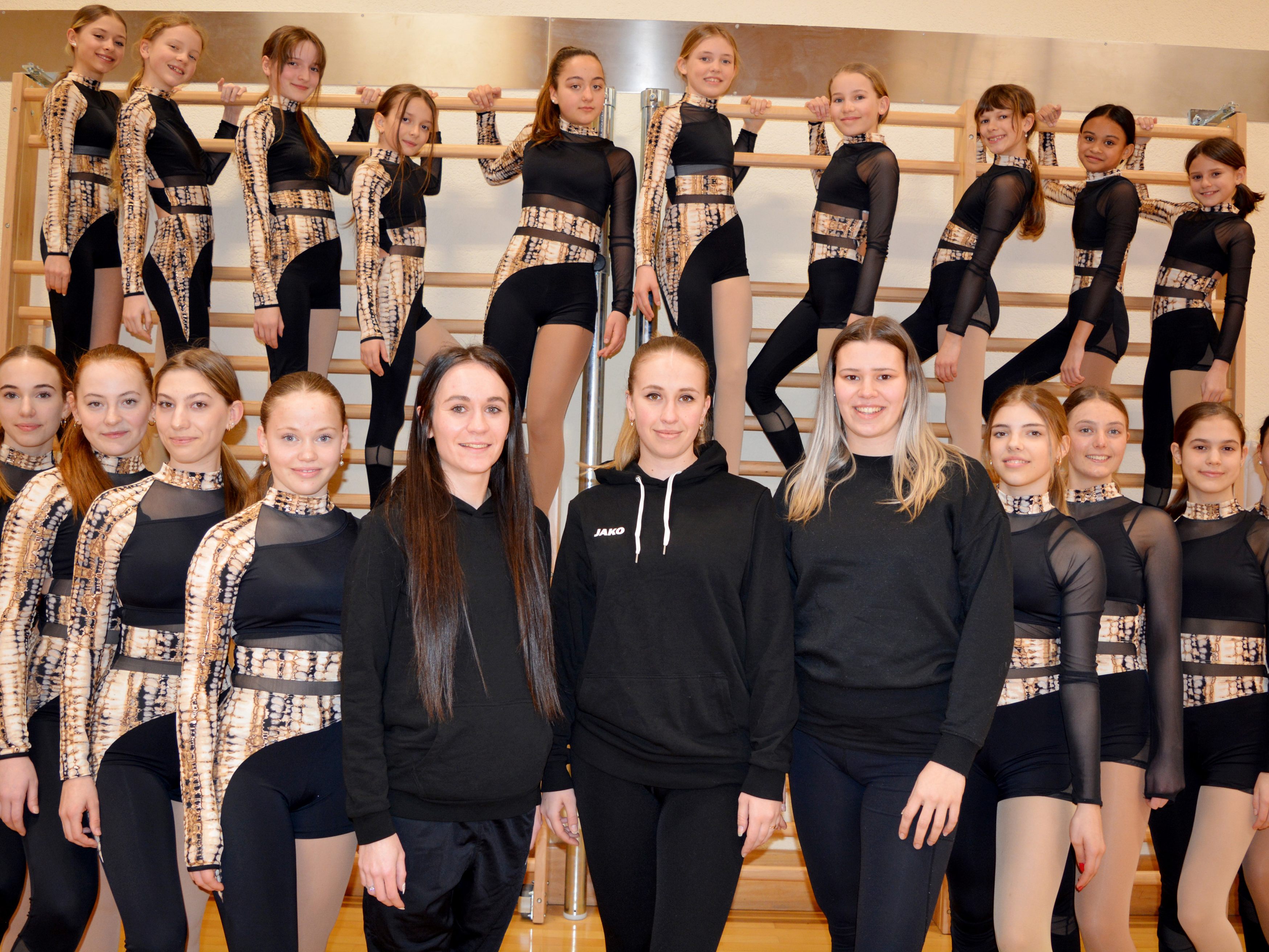 Die Harder Show Dance Gruppe im Wettkampfoutfit mit ihren drei Trainerinnen (v.l.1.Reihe Bildmitte) Claudia Feurstein, Emilia Dallosova und Lara-Sophie Berkmann.