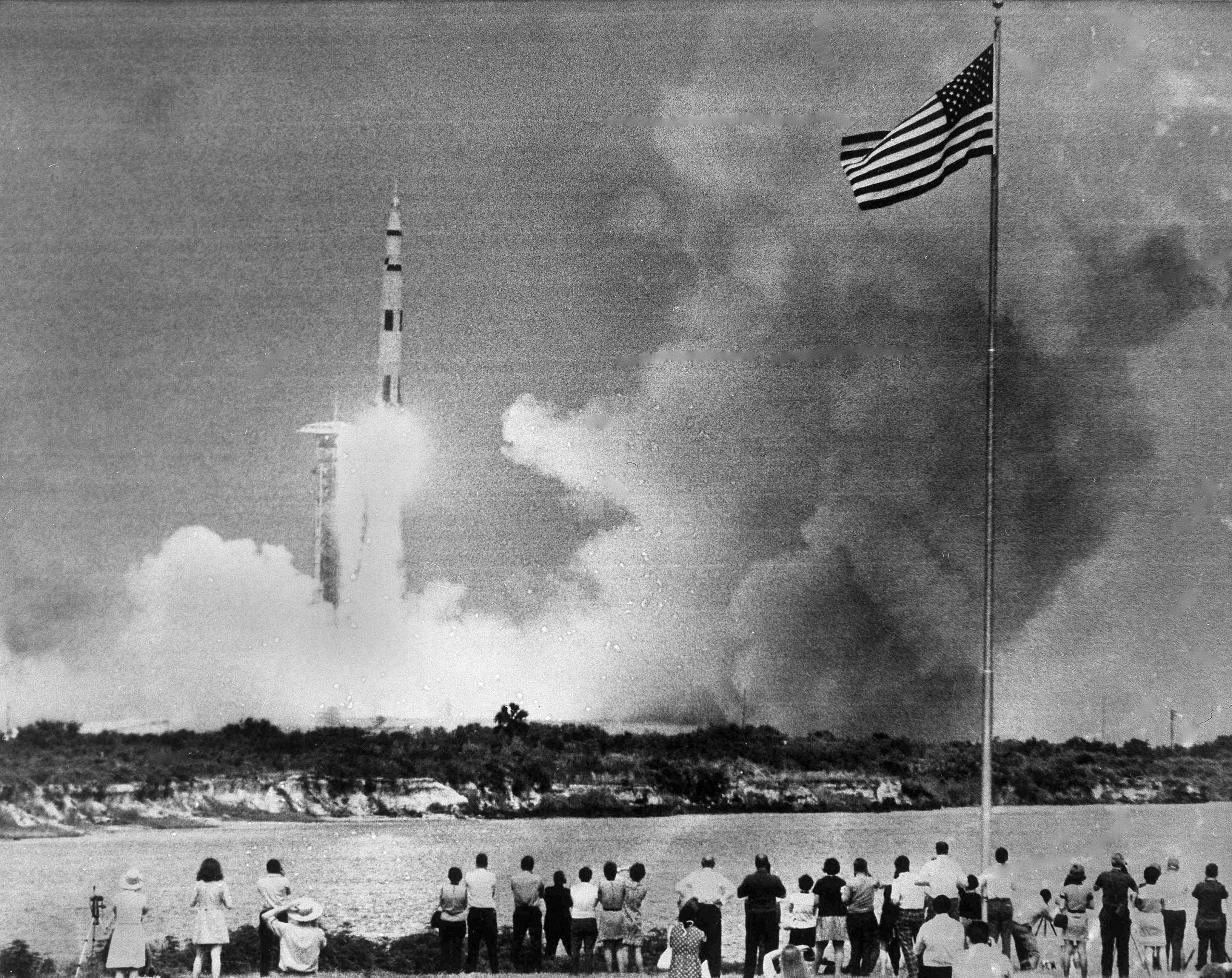 In diesem Archivfoto vom 11. April 1970 beobachten Menschen den Start der Saturn V-Rakete, die das Apollo 13 Raumschiff auf seiner Mission zum Mond von Cape Kennedy, Florida, trägt.