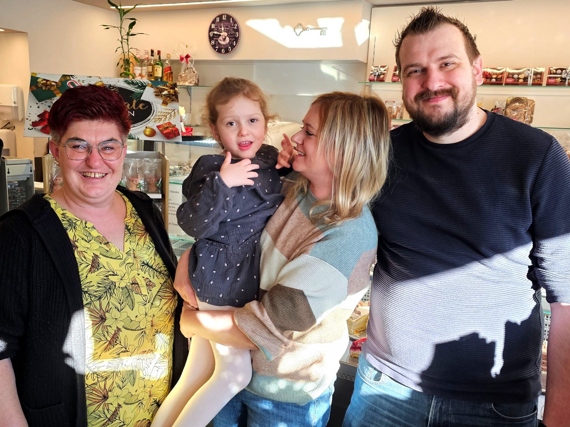 Sandra und Kevin Siller (li) nahmen unter Tränen der Rührung, den symbolischen Scheck, zur Erleichterung des Alltagslebens der schwer erkrankten Mia, von Dagmar Fijatkowski (re) Cafe Konditorei Fenkart Bludenz entgegen.