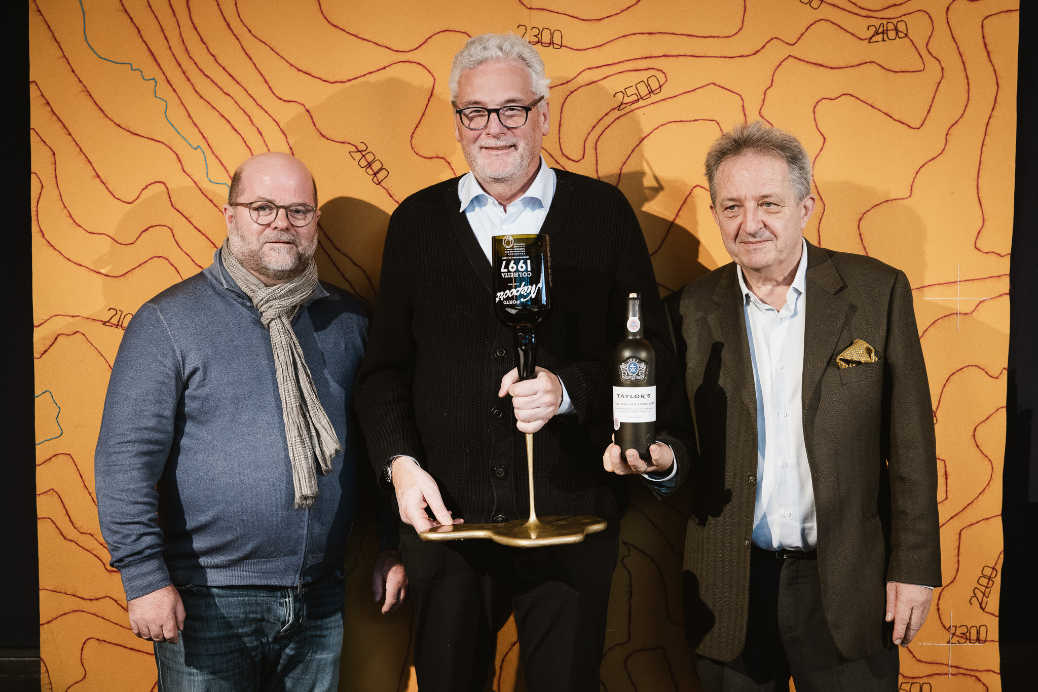 Arlberg Weinberg Best Bottle Award 2023 v.l.n.r. Erfinder BBA und Gründer von trinkreif Clemens Riedl, Gerhard Lucian (Burghotel) mit dem Gewinnerflasche Taylor's Tawny Port, Moderator Willi Balanjuk