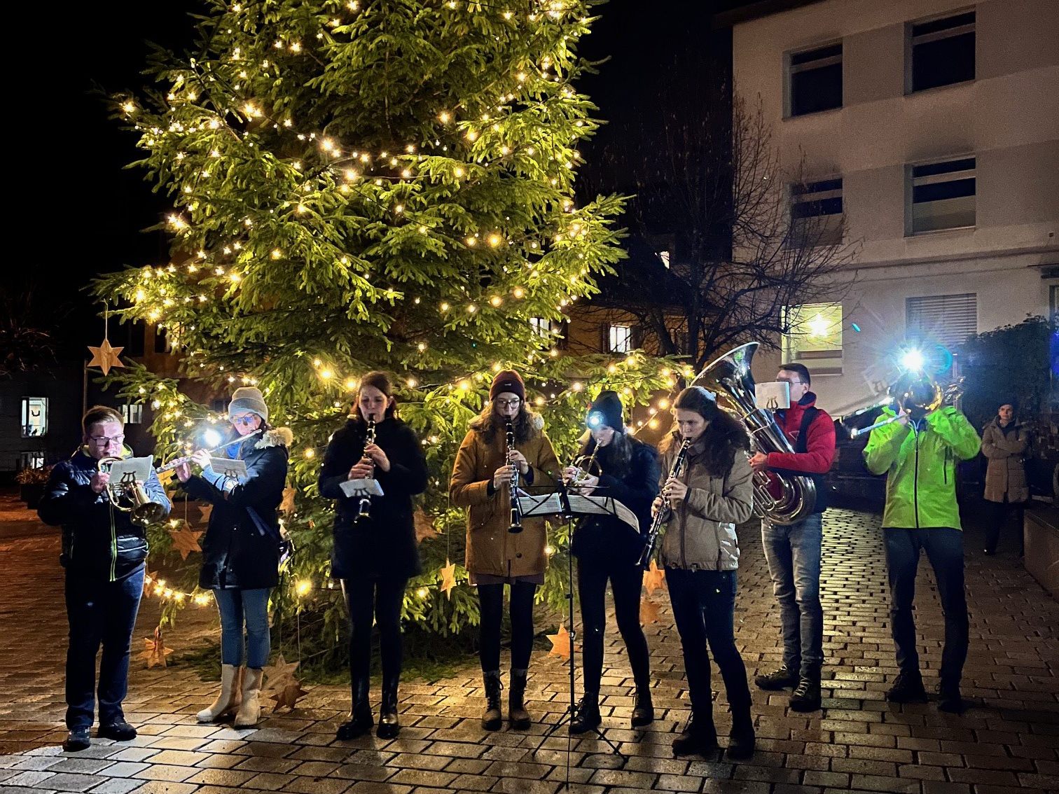 Nüziger Musikant*innen vor dem Christbaum auf dem Kirchplatz Nüziger Musikant*innen vor dem Christbaum auf dem Kirchplatz