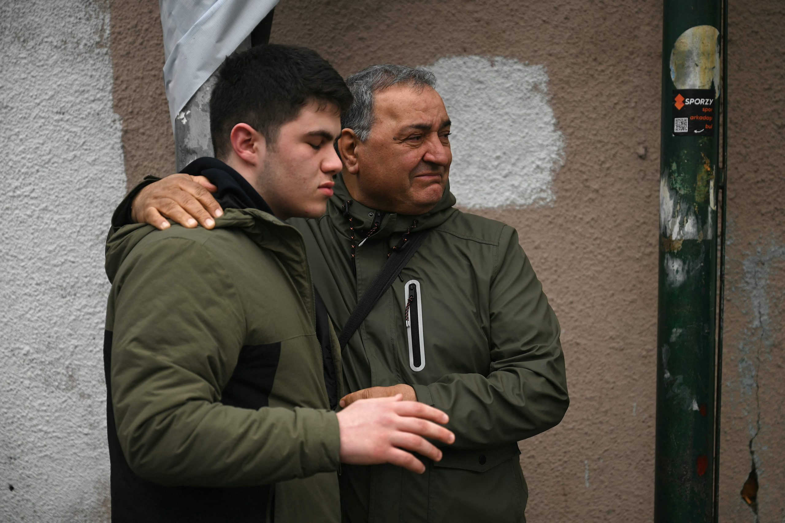 Kazim Aydemir (r.), Onkel eines der Opfer, trauert vor der Kirche Santa Maria, als türkische Anti-Aufruhr-Polizisten nach einem Angriff in Istanbul am 28. Januar 2024 die Straße blockieren. 