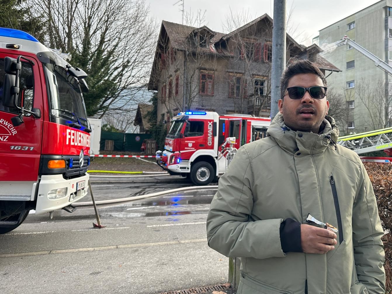Akhil vor dem Haus, das in Flammen stand. Er rief die Feuerwehr, als er das Feuer bemerkte. Akhil vor dem Haus, das in Flammen stand. Er rief die Feuerwehr, als er das Feuer bemerkte.