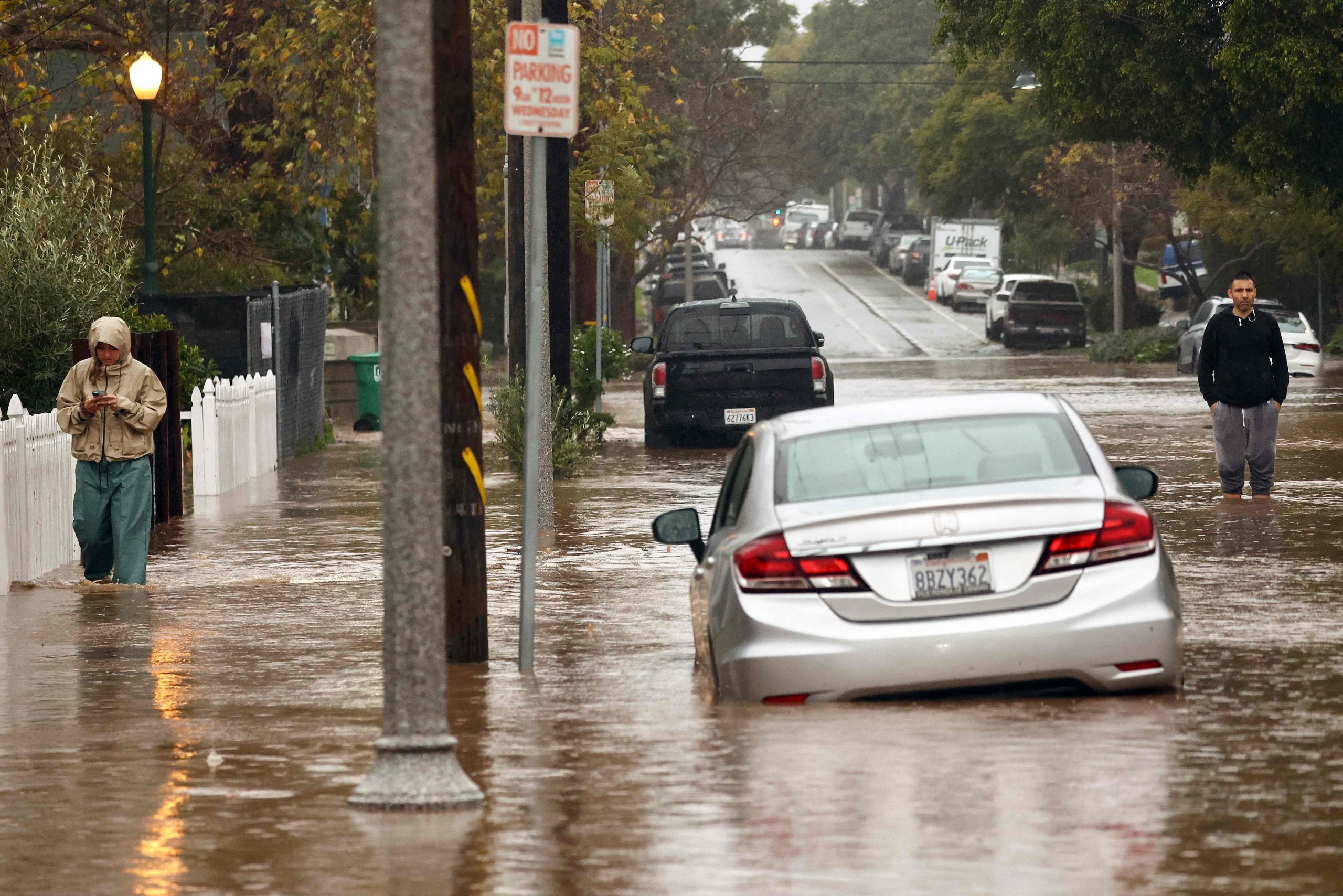 Menschen versammeln sich entlang einer überfluteten Straße, als am 4. Februar 2024 in Santa Barbara, Kalifornien, ein mächtiger, langanhaltender atmosphärischer Flusssturm, der zweite in weniger als einer Woche, über Kalifornien hereinbricht.  Menschen versammeln sich entlang einer überfluteten Straße, als am 4. Februar 2024 in Santa Barbara, Kalifornien, ein mächtiger, langanhaltender atmosphärischer Flusssturm, der zweite in weniger als einer Woche, über Kalifornien hereinbricht.