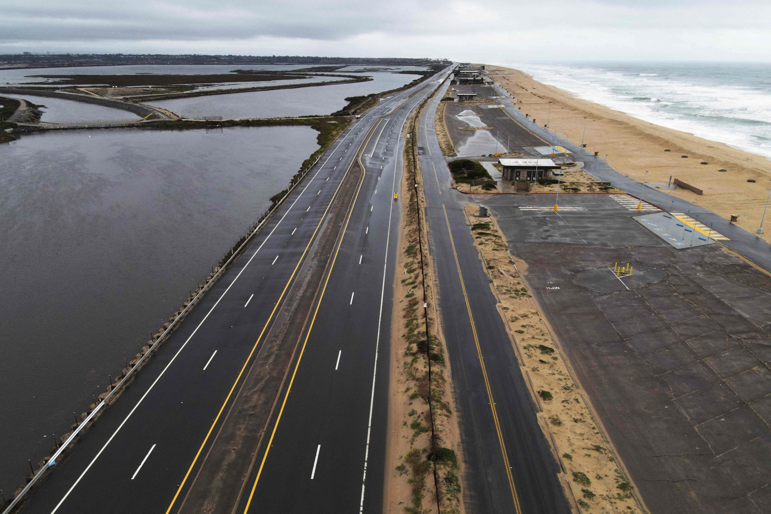 Dieses am 1. Februar 2024 aufgenommene Luftbild zeigt einen Abschnitt des Pacific Coastal Highway, der während eines Regensturms in Bolsa Chica in der Nähe von Huntington Beach, Kalifornien, wegen Überschwemmungen gesperrt war.  Dieses am 1. Februar 2024 aufgenommene Luftbild zeigt einen Abschnitt des Pacific Coastal Highway, der während eines Regensturms in Bolsa Chica in der Nähe von Huntington Beach, Kalifornien, wegen Überschwemmungen gesperrt war.