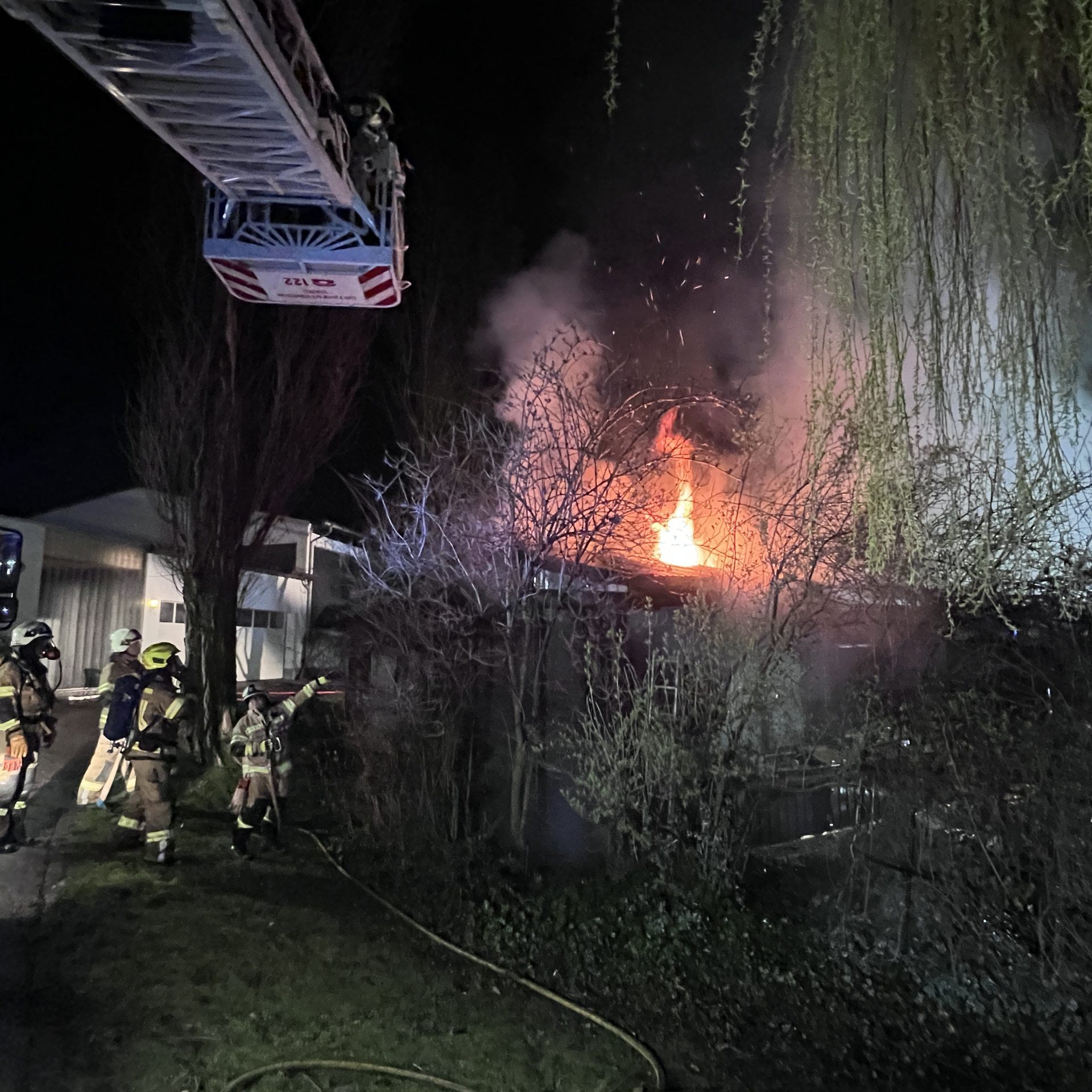 Die Flammen schlagen aus dem Dach des Hauses.