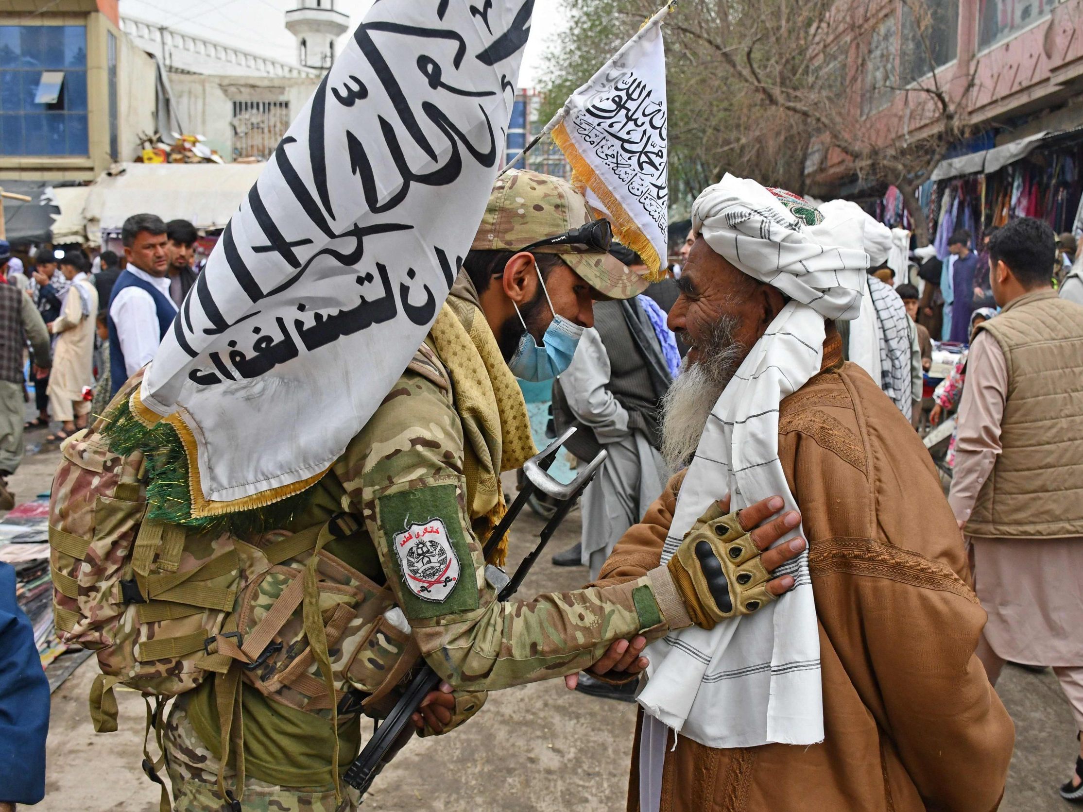 Ein Sicherheitsbeauftragter der Taliban begrüßt einen muslimischen Gläubigen nach dem Gebet.