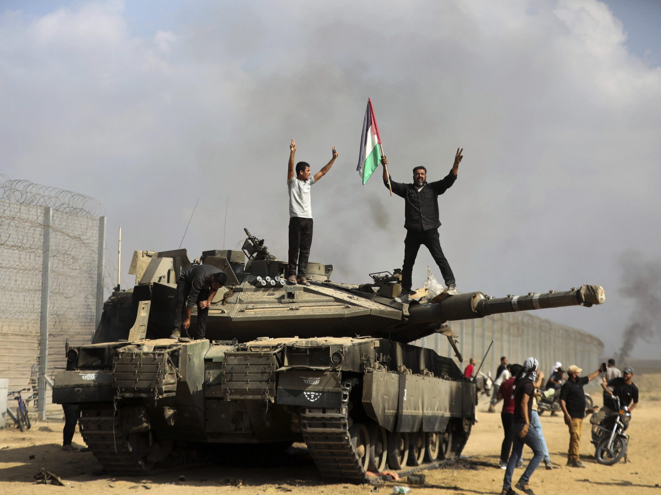 Palästinenser feiern einen zerstörten israelischen Panzer bei Khan Younis (17. März 2024).