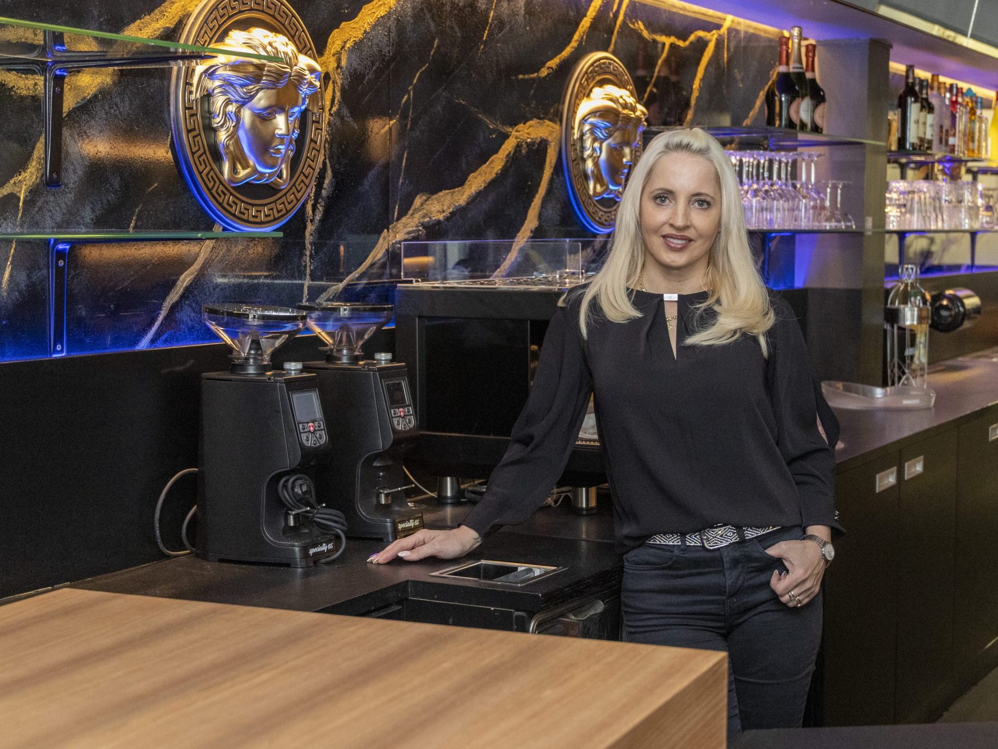Die Versace-Logos zieren die Wand in Marmoroptik. Dahinter befindet sich der Feuerschutz. Die Versace-Logos zieren die Wand in Marmoroptik. Dahinter befindet sich der Feuerschutz.
