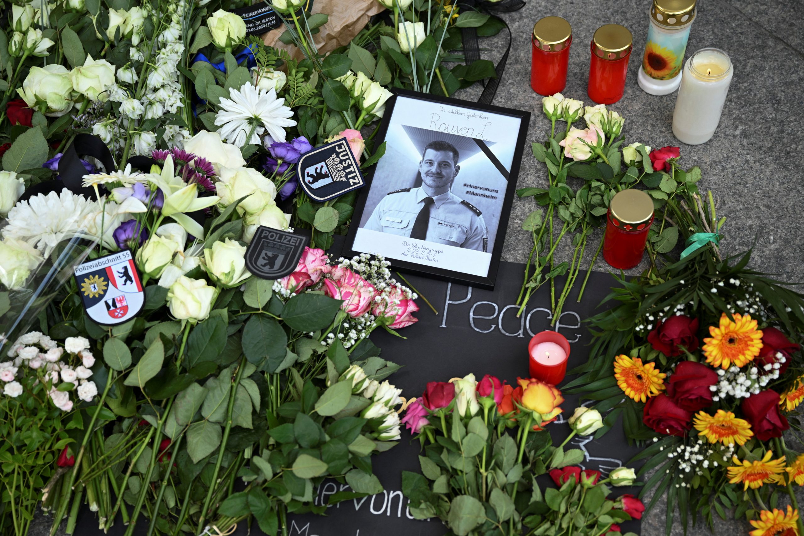 Ein Foto und Blumen sind vor der Landesvertretung Baden-Württemberg niedergelegt, am Tag eines Trauermarsches für den 29-jährigen Polizisten Rouven L., der nach einem Messerangriff in Mannheim gestorben ist, in Berlin, Deutschland, am 7. Juni 2024.