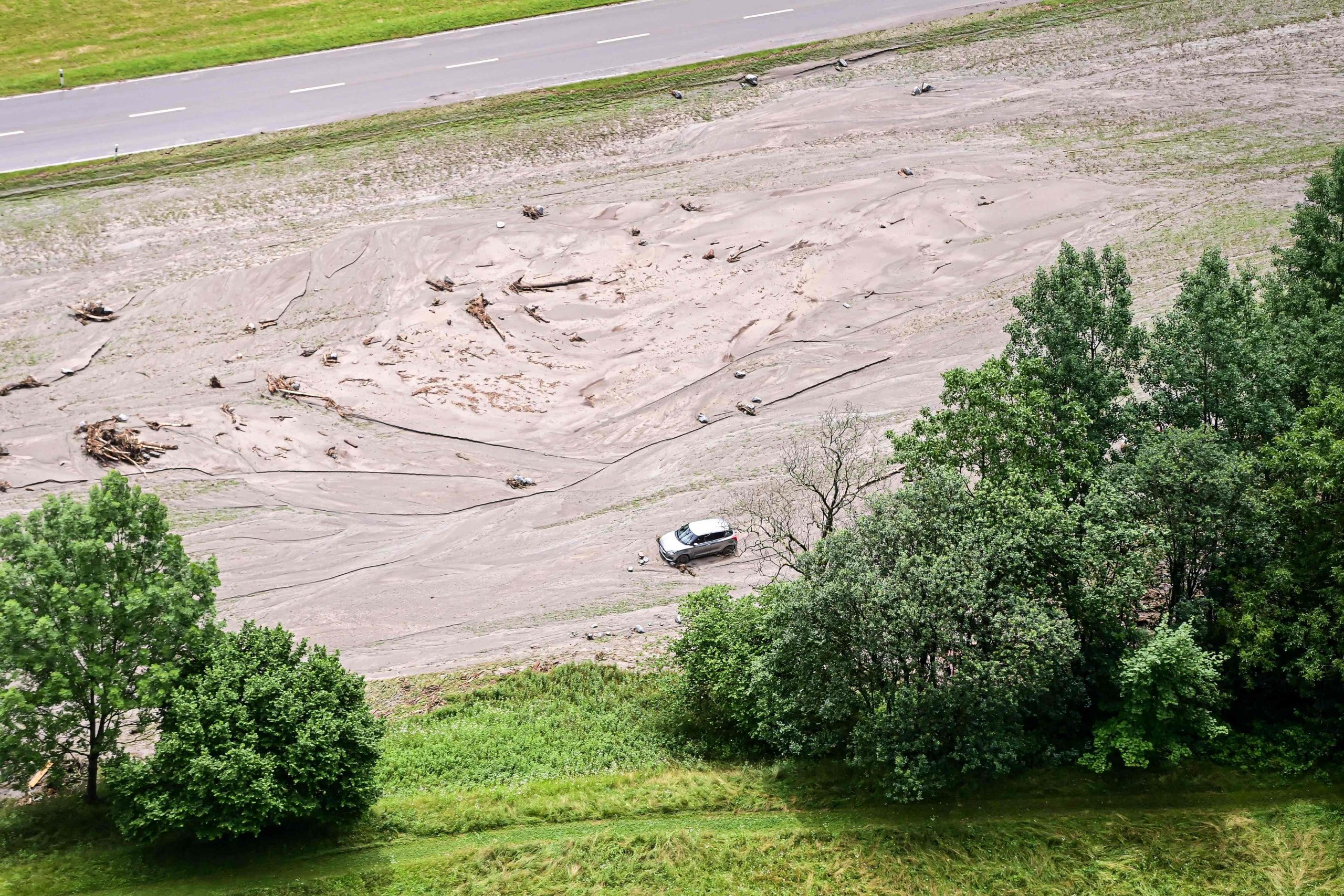 Dieses Luftbild zeigt ein im Schlamm steckendes Auto im Kanton Graubünden in der Schweiz Dieses Luftbild zeigt ein im Schlamm steckendes Auto im Kanton Graubünden in der Schweiz