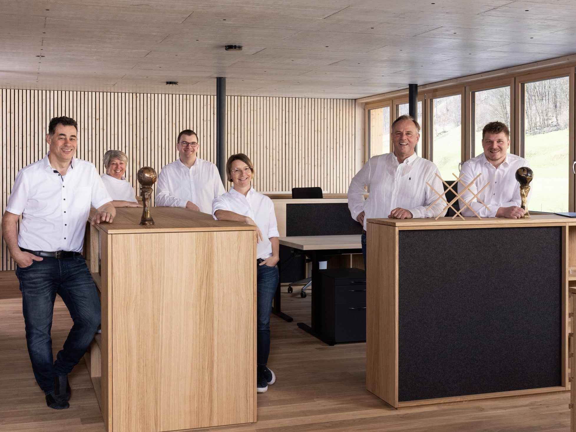 Die beiden Geschäftsführer Günter (zweiter von rechts) und Oliver Morscher (rechts) mit dem Team von Morscher Bauprojekte am neuen Arbeitsplatz in Mellau.