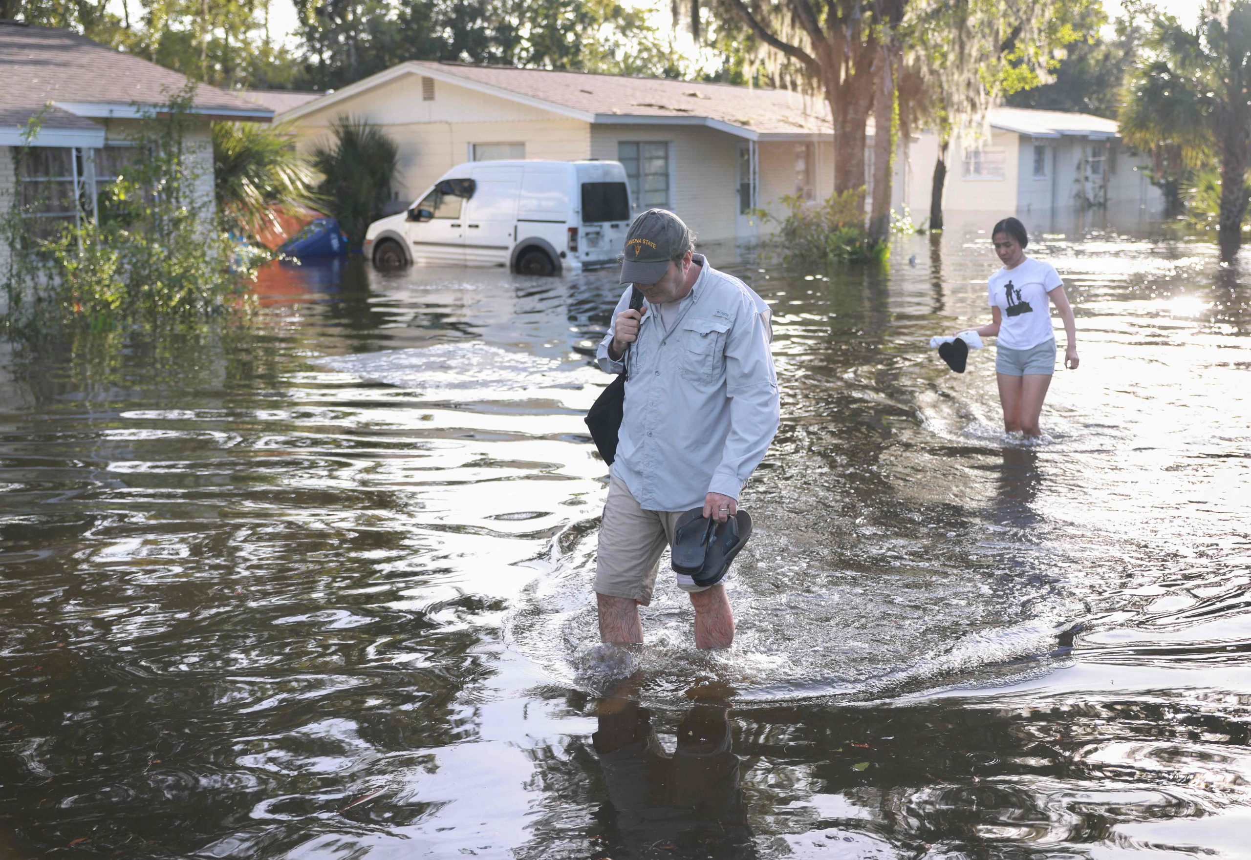 Menschen gehen durch eine überflutete Straße, nachdem der Hurrikan Helene die Gegend getroffen hat, während er am 27. September 2024 vor der Küste von Crystal River, Florida, vorbeizog.