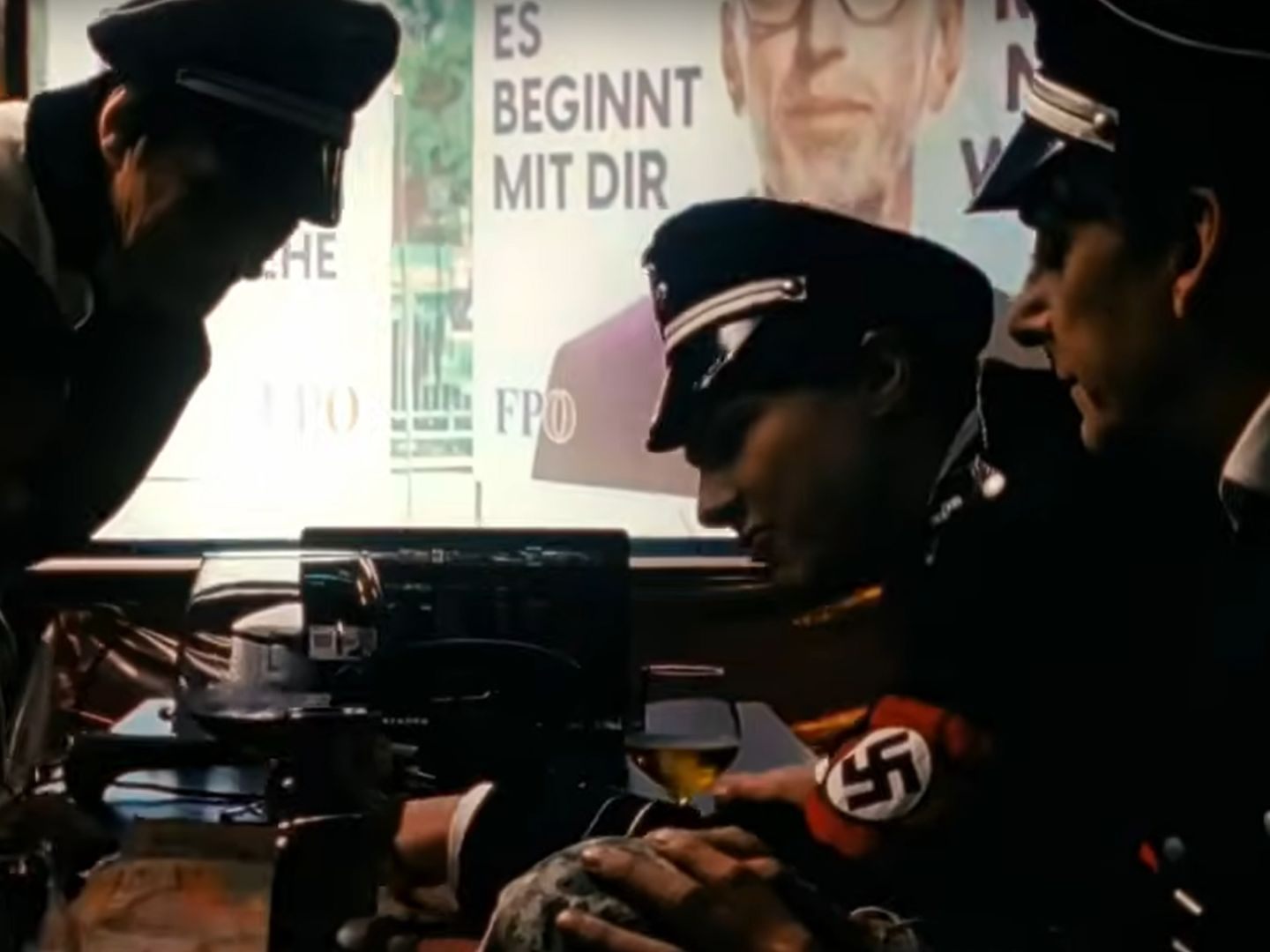 Die Performer sind in Uniformen mit Hakenkreuz-Binden und Hitler-Bart zu sehen. Die Performer sind in Uniformen mit Hakenkreuz-Binden und Hitler-Bart zu sehen.