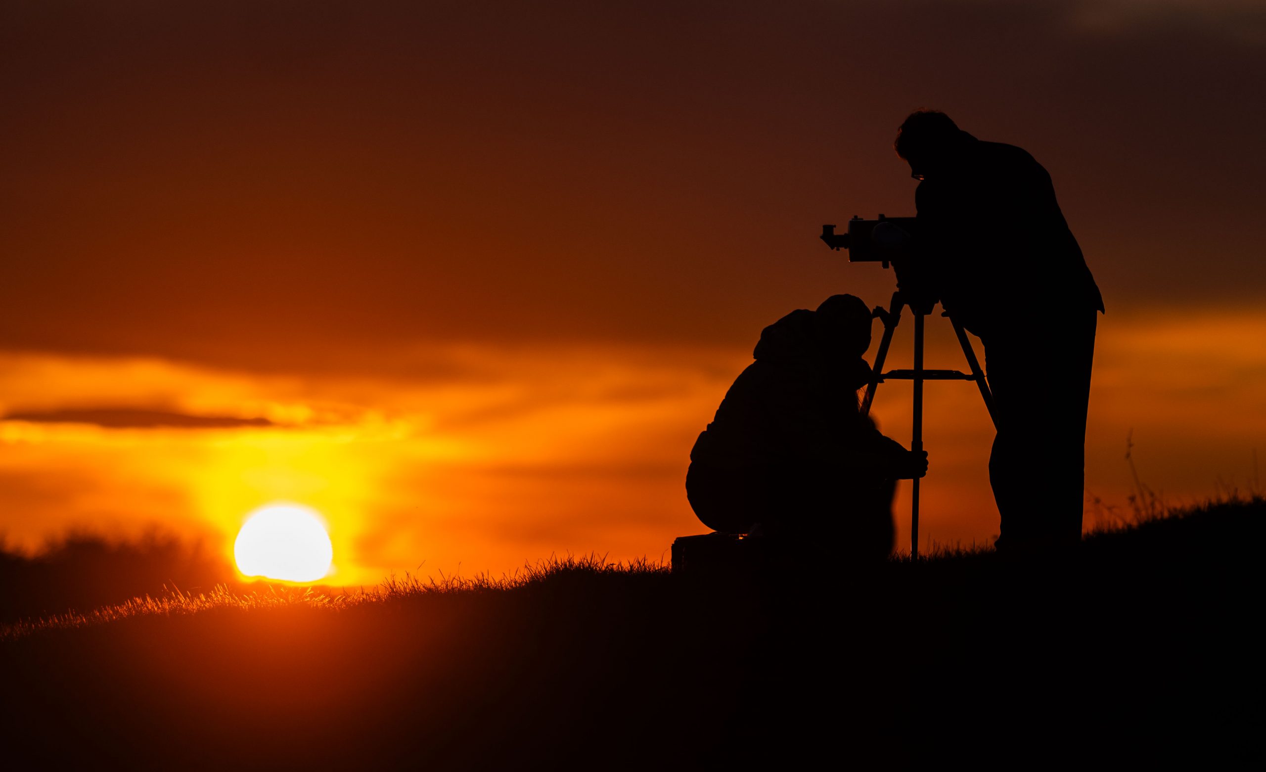 Zwei Personen mit einem Teleskop Zwei Personen mit einem Teleskop