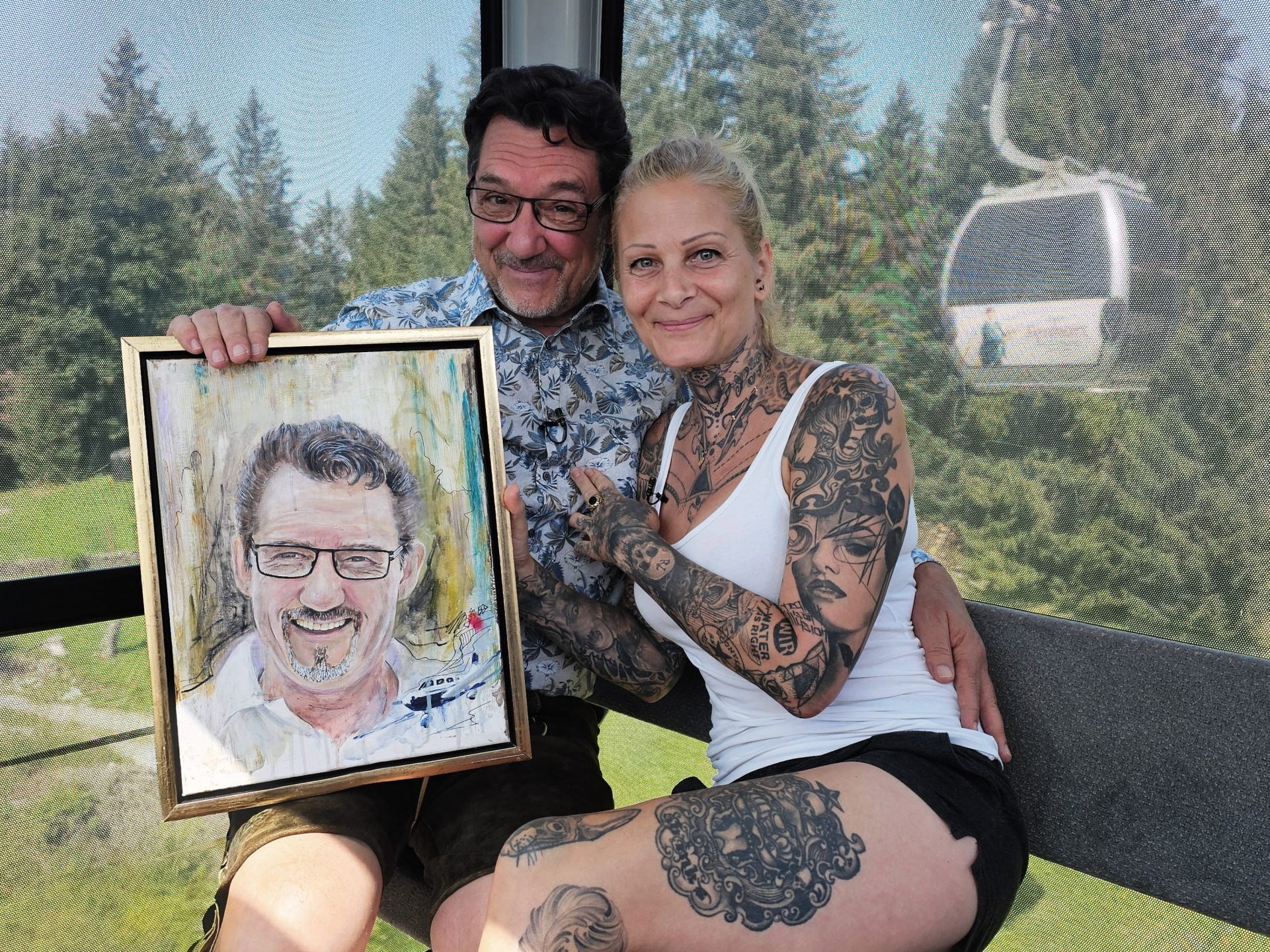 Tattooartist und Malerin Bianca Fetzel (re) ist zu Gast in der Fernsehgondel bei Andreas Seeburger  (li) der mit einem Portrait überrascht wurde.