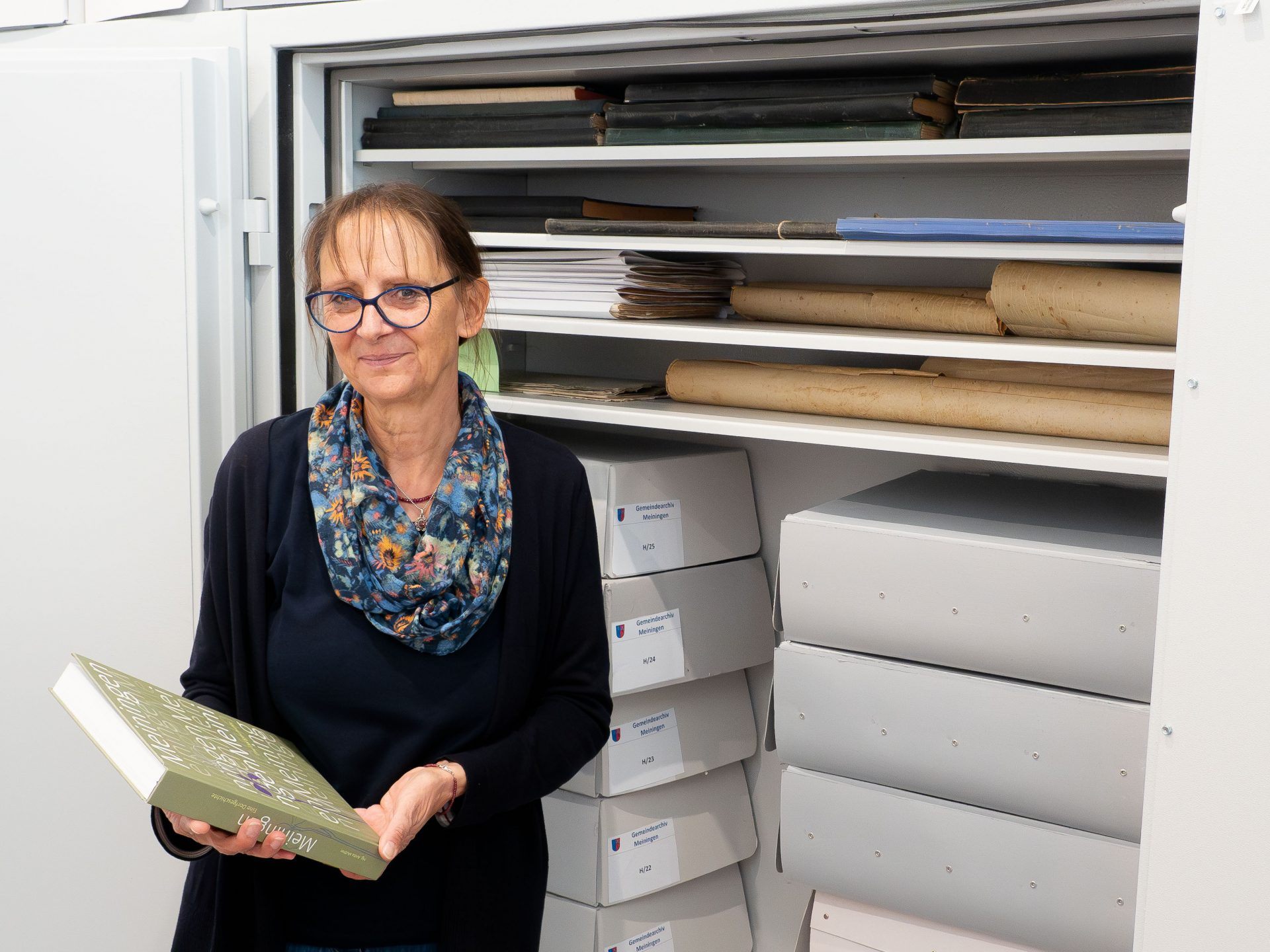 Die Archivarin Dr. Anita Muther mit ihrem Dorfgeschichte-Buch vor dem Stahlschrank mit besonders schützenswerter Archivalien. Die Archivarin Dr. Anita Muther mit ihrem Dorfgeschichte-Buch vor dem Stahlschrank mit besonders schützenswerter Archivalien.