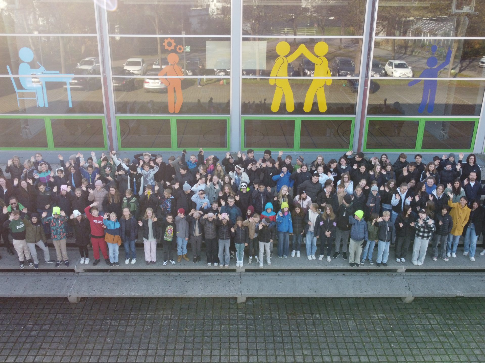Die Schülerinnen und Schüler der Mittelschule vor den Figuren an der Fensterfront Anfang November 2024.