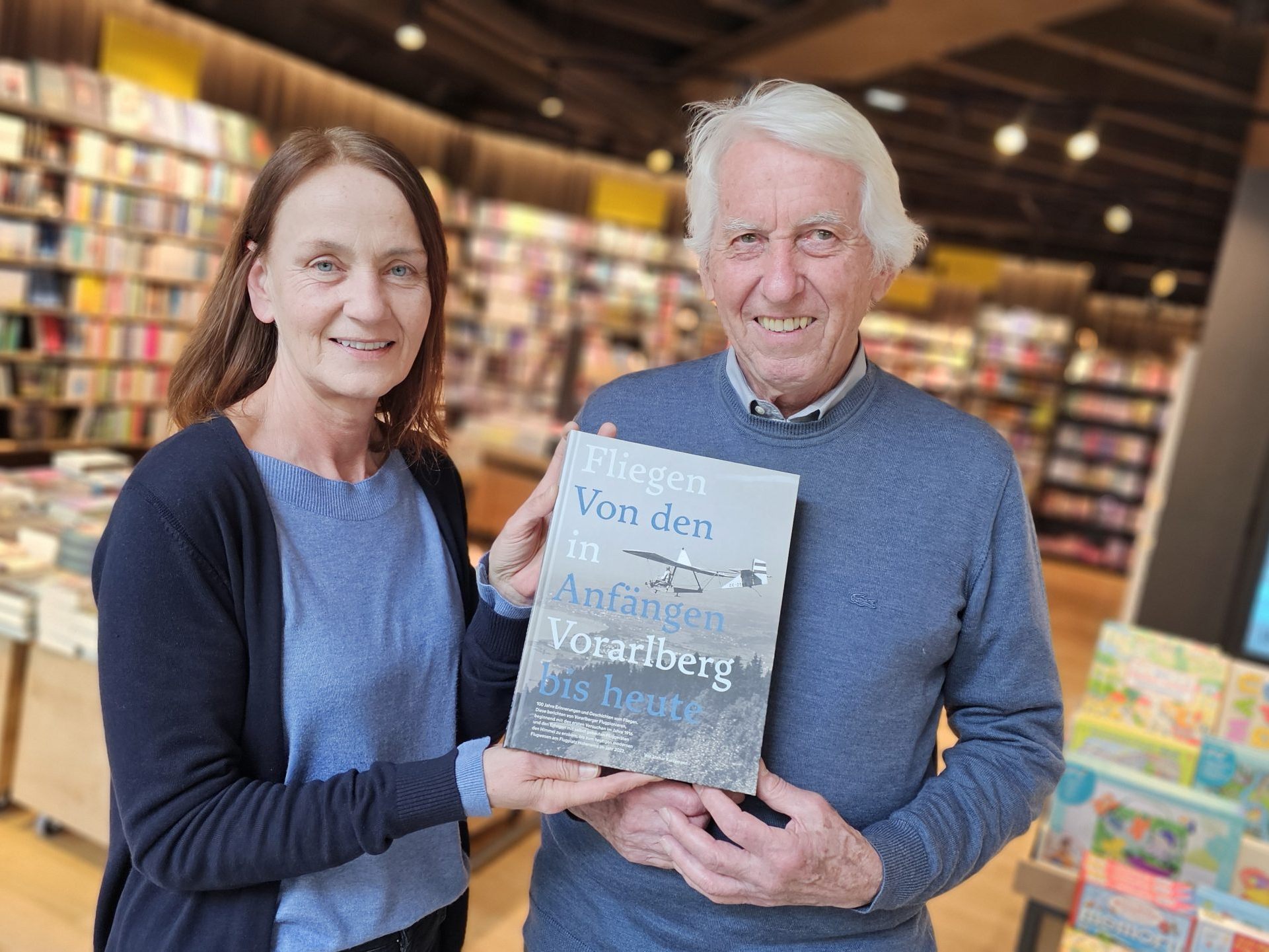 Anita Figo (li) von DAS BUCH im Messepark und Segelfliegerpilot sowie Buchautor Lothar Kurzemann, mit seinem Historienwerk "Fliegen in Vorarlberg - von den Anfängen bis heute."