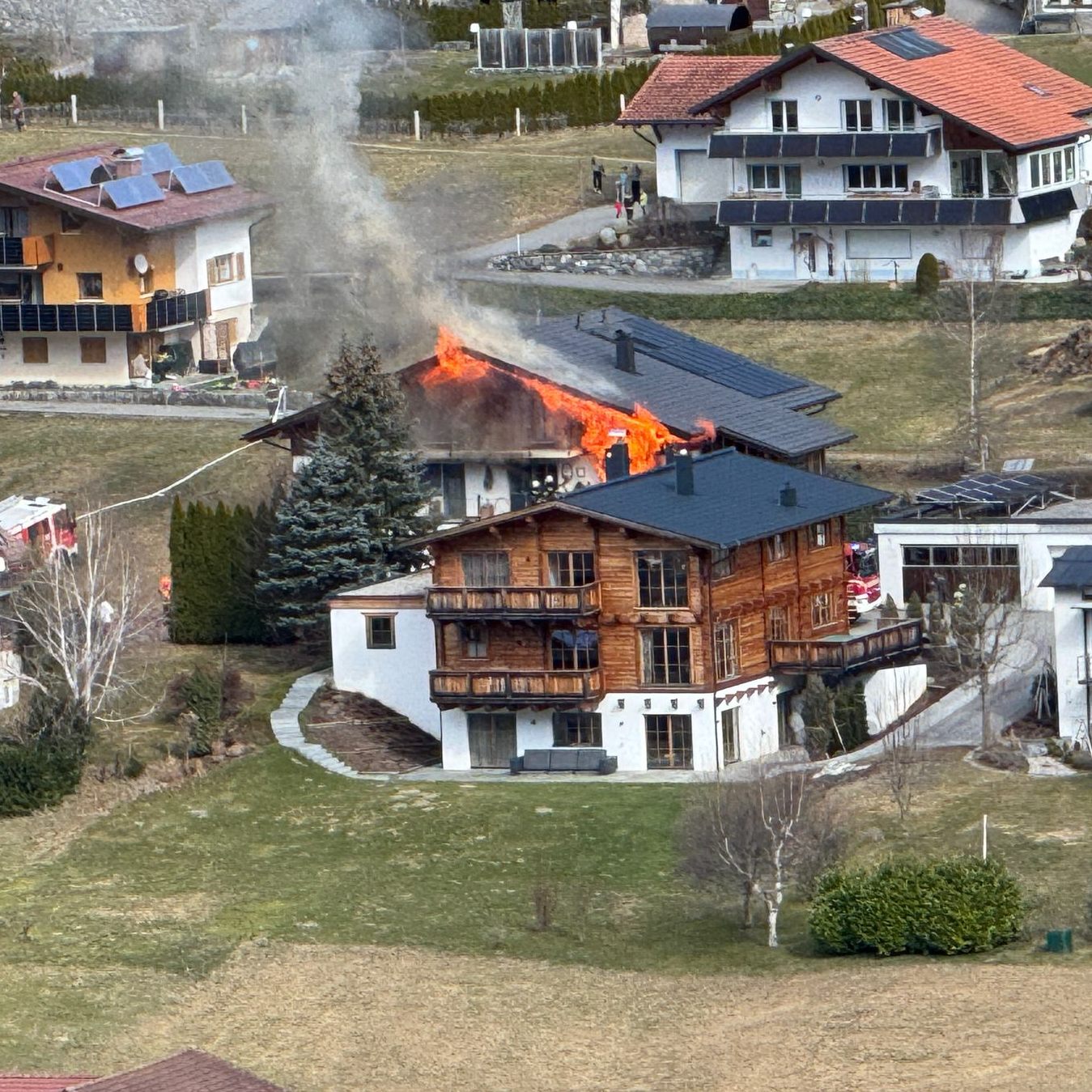 Flammen schlagen aus dem Dach des Gebäudes.
