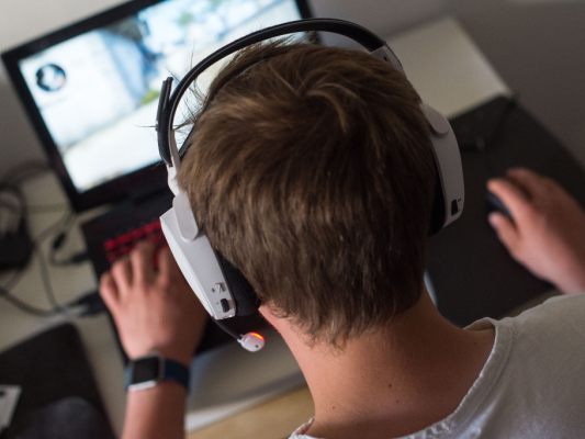 Videopiele am Laptop mit Headset sind beliebter Zeitvertreib Videopiele am Laptop mit Headset sind beliebter Zeitvertreib